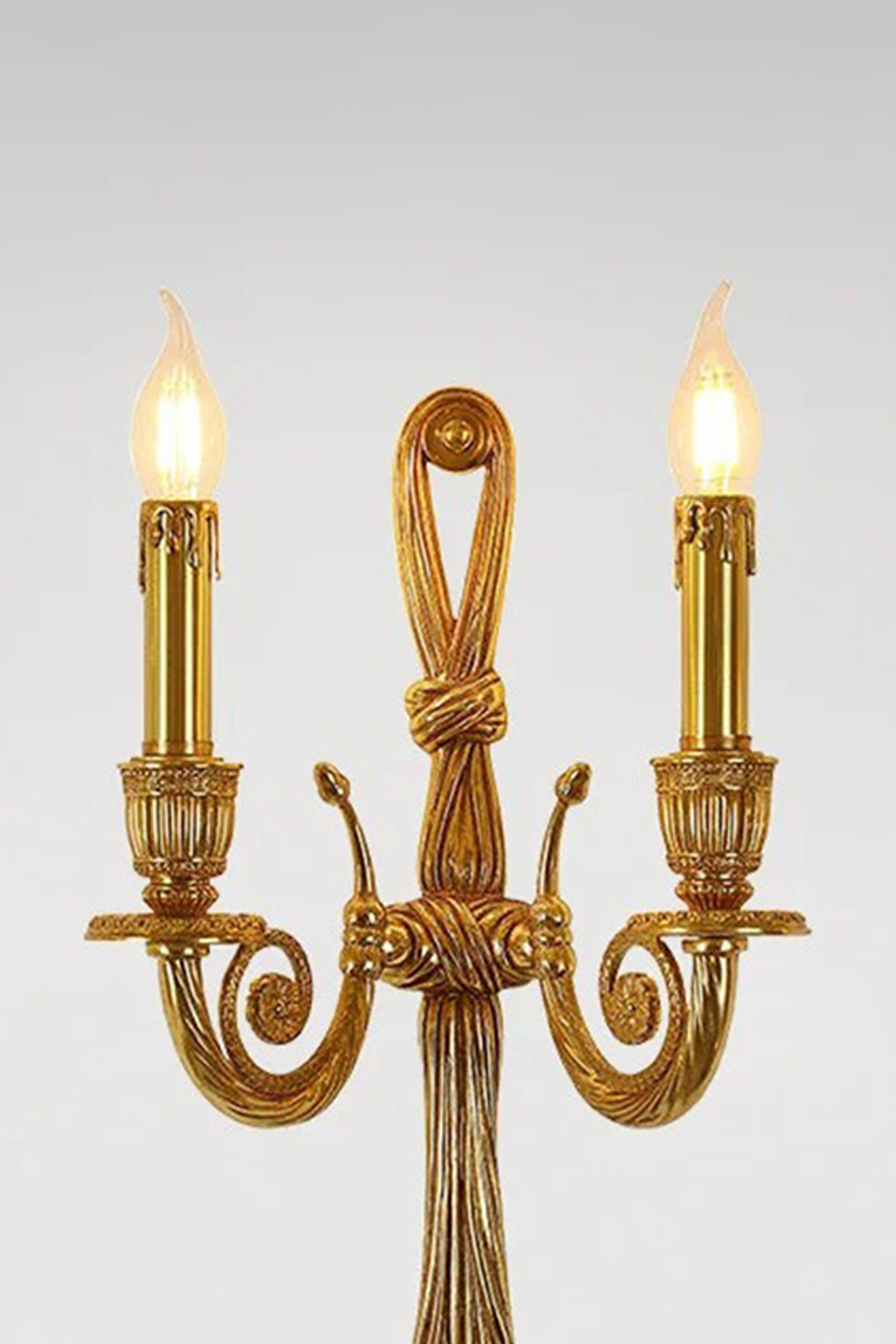Honoria Rope and Tassel Brass Sconce | Brass and Metal | Full front illuminated view displayed against a solid light grey background | Samu Lamp