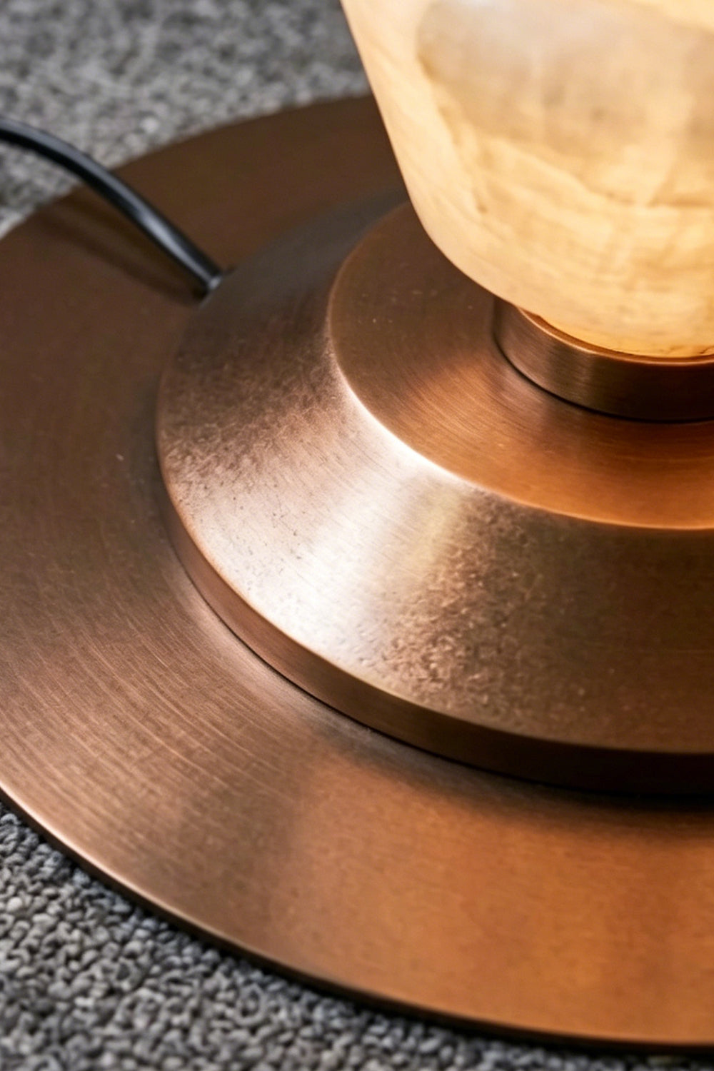 Brass Base Detail | Brass | Close-up of the circular brushed brass base on grey surface | Samu Lamp