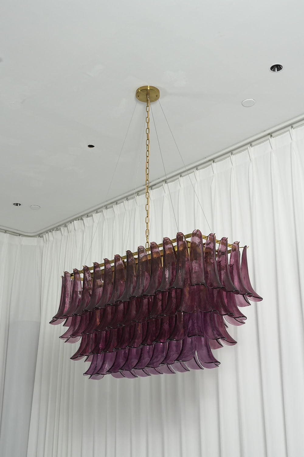 Ilvesse Amethyst Glass Petal Rectangular Chandelier | Amethyst Glass and Brass | Real-life angled perspective on a white curtain backdrop | Samu Lamp