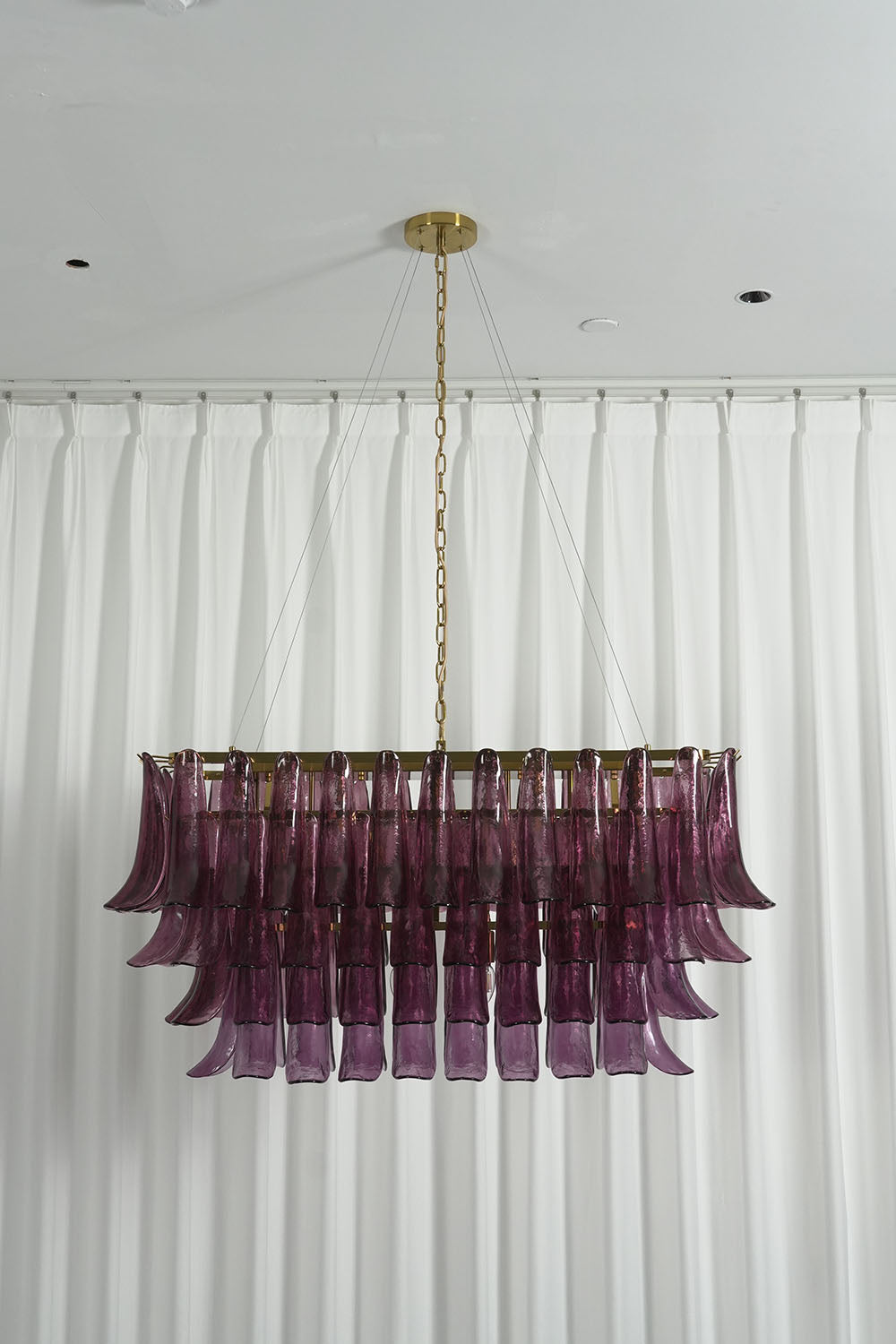 Ilvesse Amethyst Glass Petal Rectangular Chandelier | Amethyst Glass and Brass | Full vertical installation view hanging against white window drapes | Samu Lamp