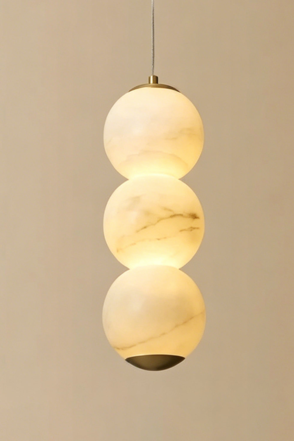 Imperial Epoch Alabaster Pendant Lamp | Metal, Alabaster | Close-up of three stacked stone spheres against a warm neutral background | Samu Lamp