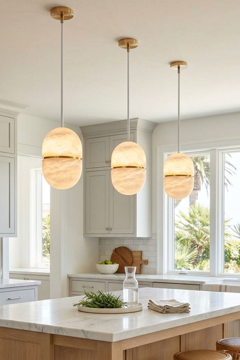 Isaline Banded Capsule Alabaster Pendant Light hanging in a modern kitchen above an island.