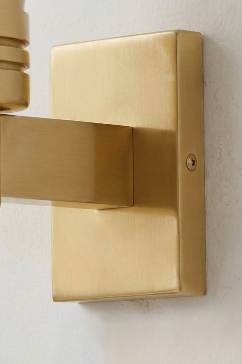 Isolde Alabaster Orb Wall Sconce | Natural Alabaster and Aged Brass | Side perspective close-up of the square rectangular metal backplate against a white wall | Samu Lamp