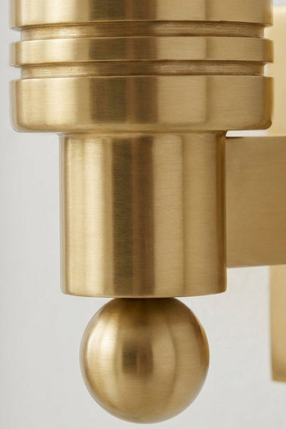 Isolde Alabaster Orb Wall Sconce | Natural Alabaster and Aged Brass | Detailed close-up macro shot of the ribbed brass cylinder holder and the small ball finial | Samu Lamp