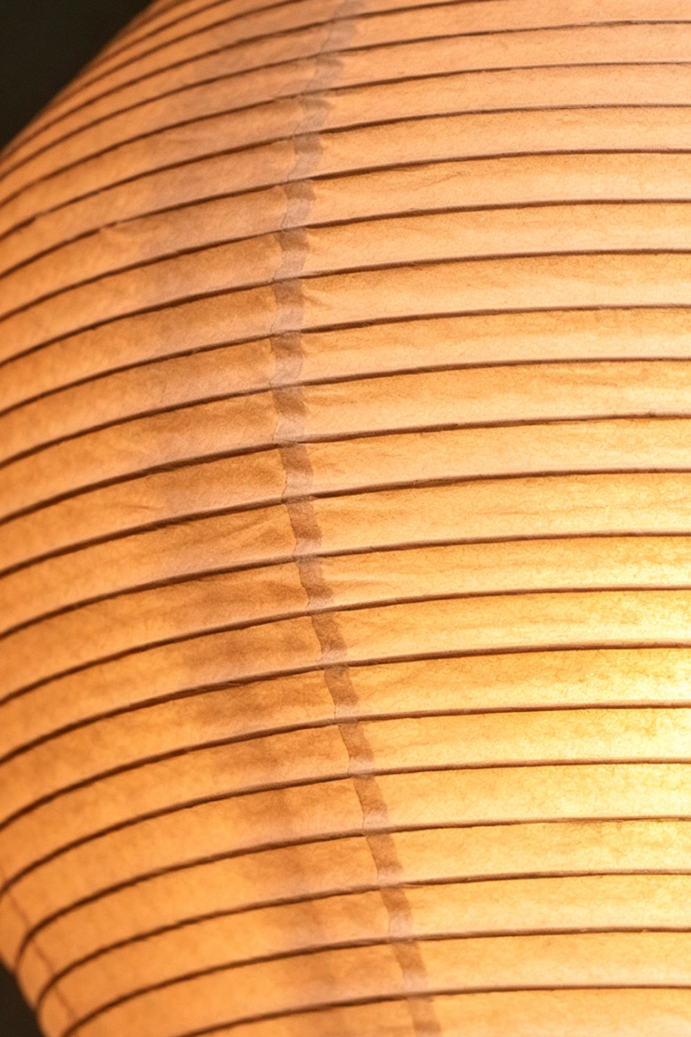 Isolde Stacked Paper Pendant Lamp | Textured Ribbed Paper | Macro close-up shot detailing the intricate ribbed texture of the warm glowing paper shade | Samu Lamp
