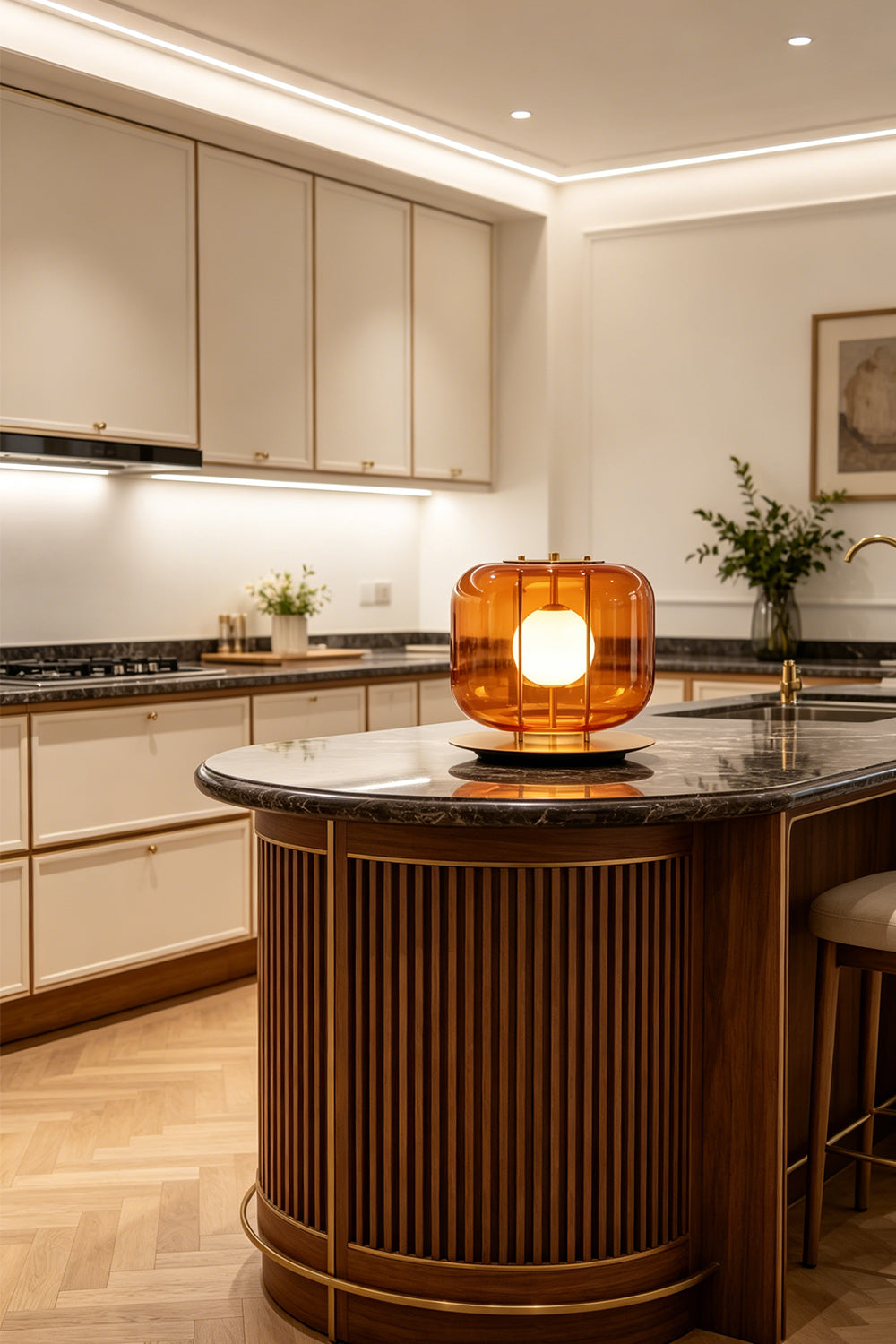 Jasper Colorblock Table Lamp | Glass, Metal | Amber orange glass block lamp lit elegantly on a fluted dark wood kitchen island counter with a polished black marble countertop | Samu Lamp
