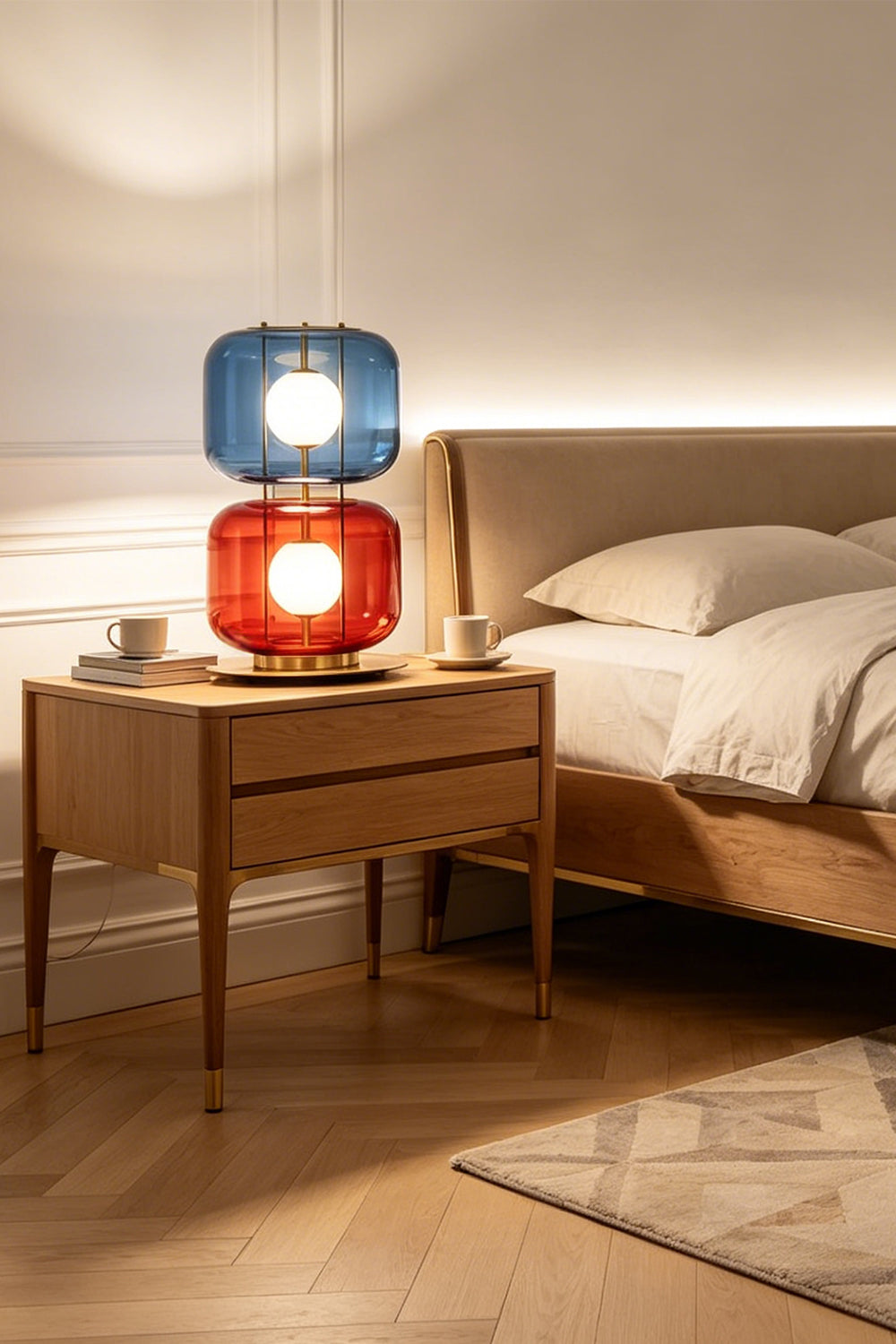 Jasper Colorblock Table Lamp | Glass, Metal | Closer room view of the colorful stacked glass lamp radiating warm light on a bedroom nightstand with linen textures | Samu Lamp