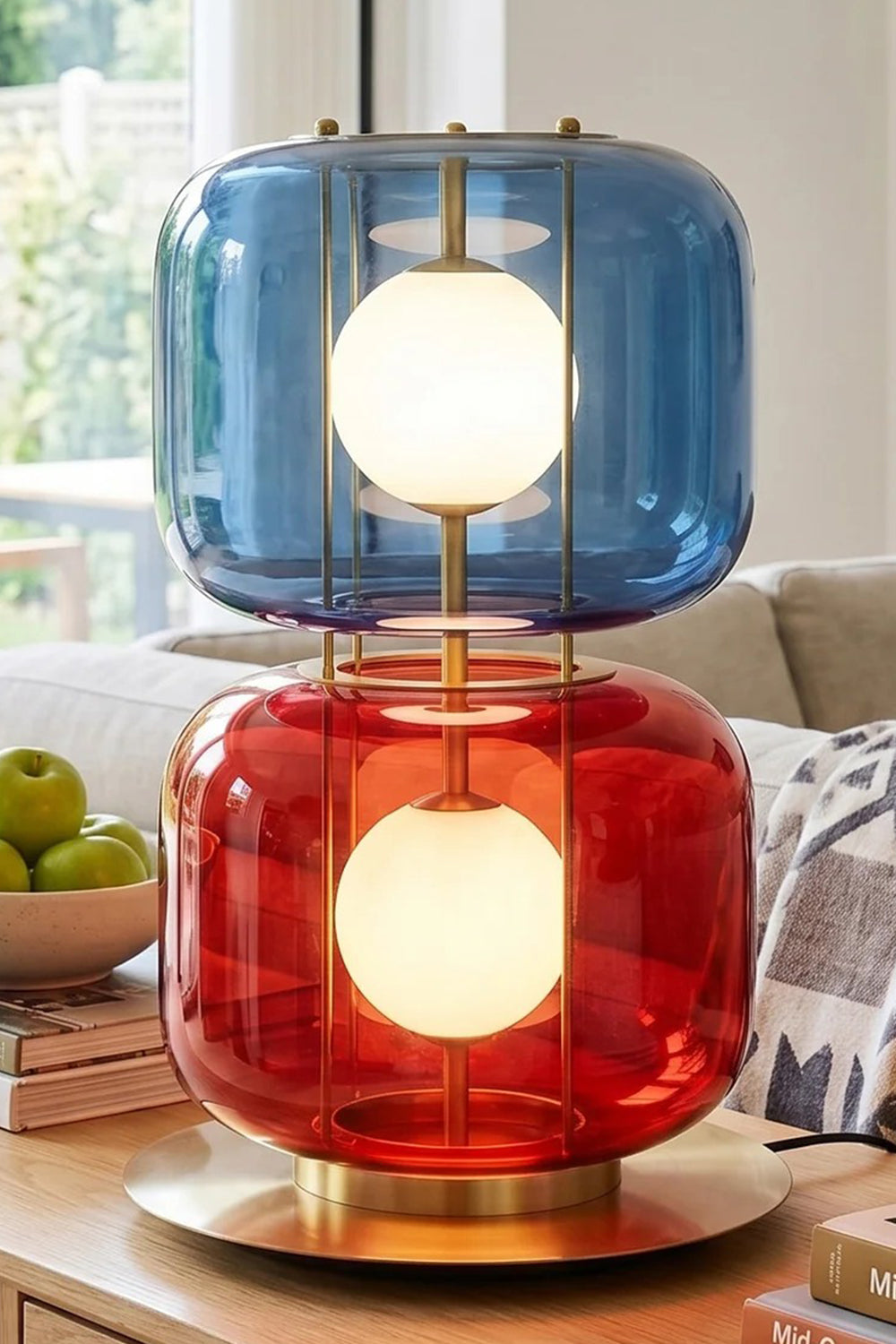 Jasper Colorblock Table Lamp | Glass, Metal | Fully lit blue and red glass stacked accent lamp standing on a wooden surface in a cozy contemporary residential living space | Samu Lamp