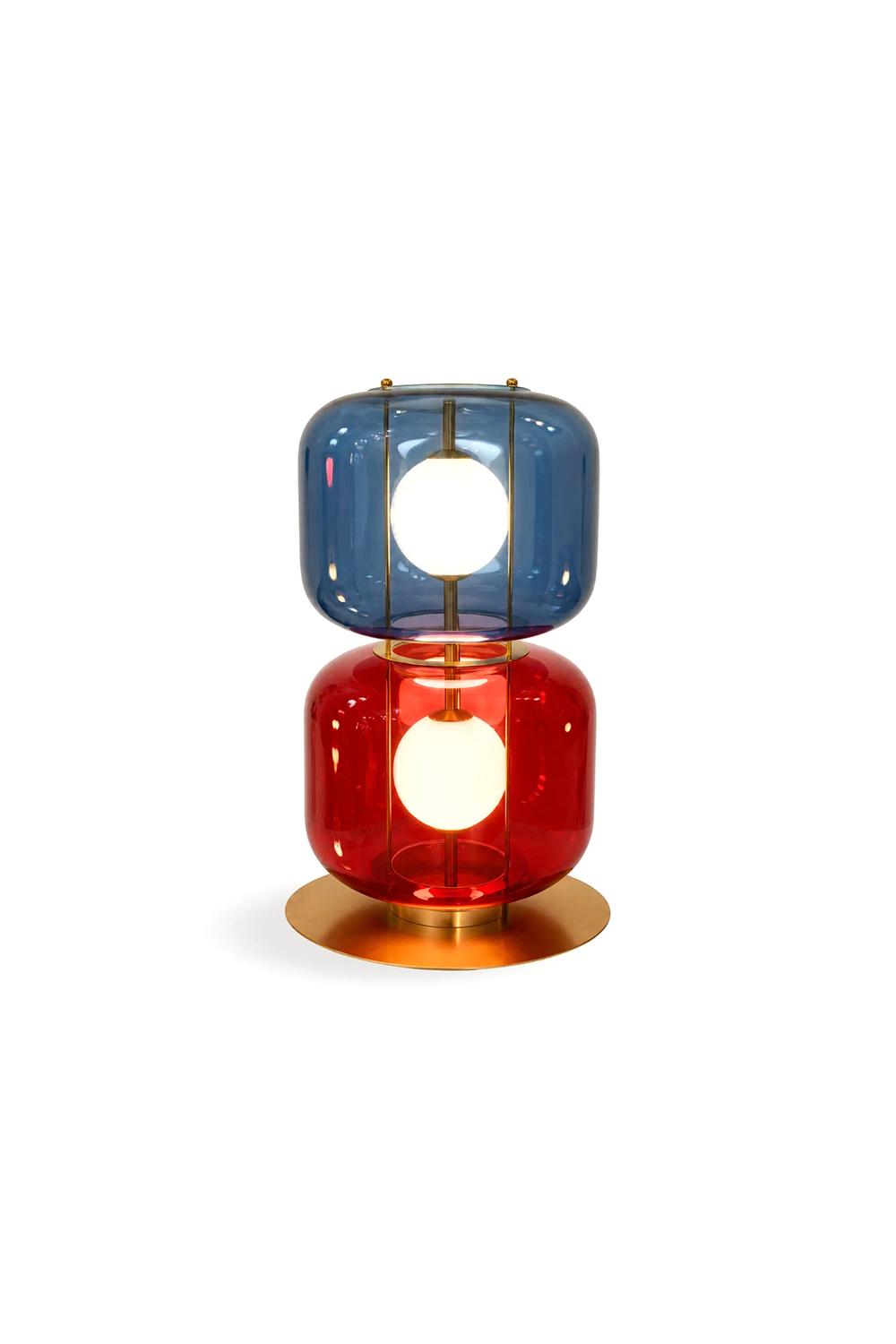 Jasper Colorblock Table Lamp | Glass, Metal | Isolated lit product view of a modern stacked color-block table lamp featuring a top blue glass module and a bottom red glass module on a gold brass base, each enclosing a glowing white frosted globe | White background | Samu Lamp