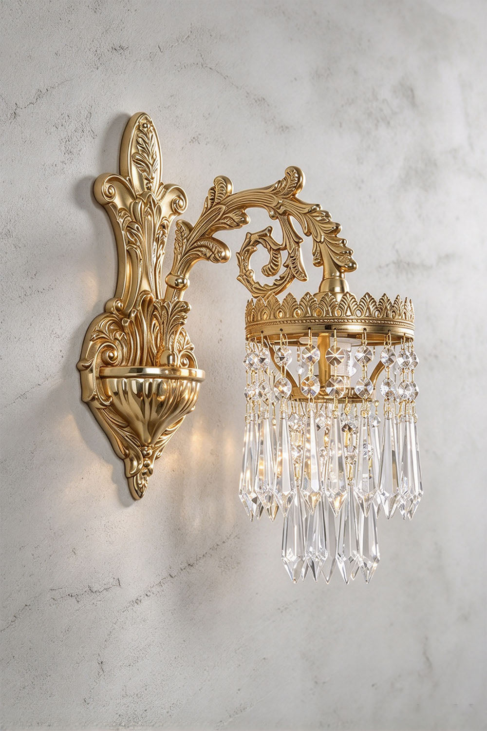 Josseline Brass Crystal Crown Wall Lamp | Cut Crystal and Brass | Angled product view of the single-arm sconce mounted on a grey wall | Samu Lamp
