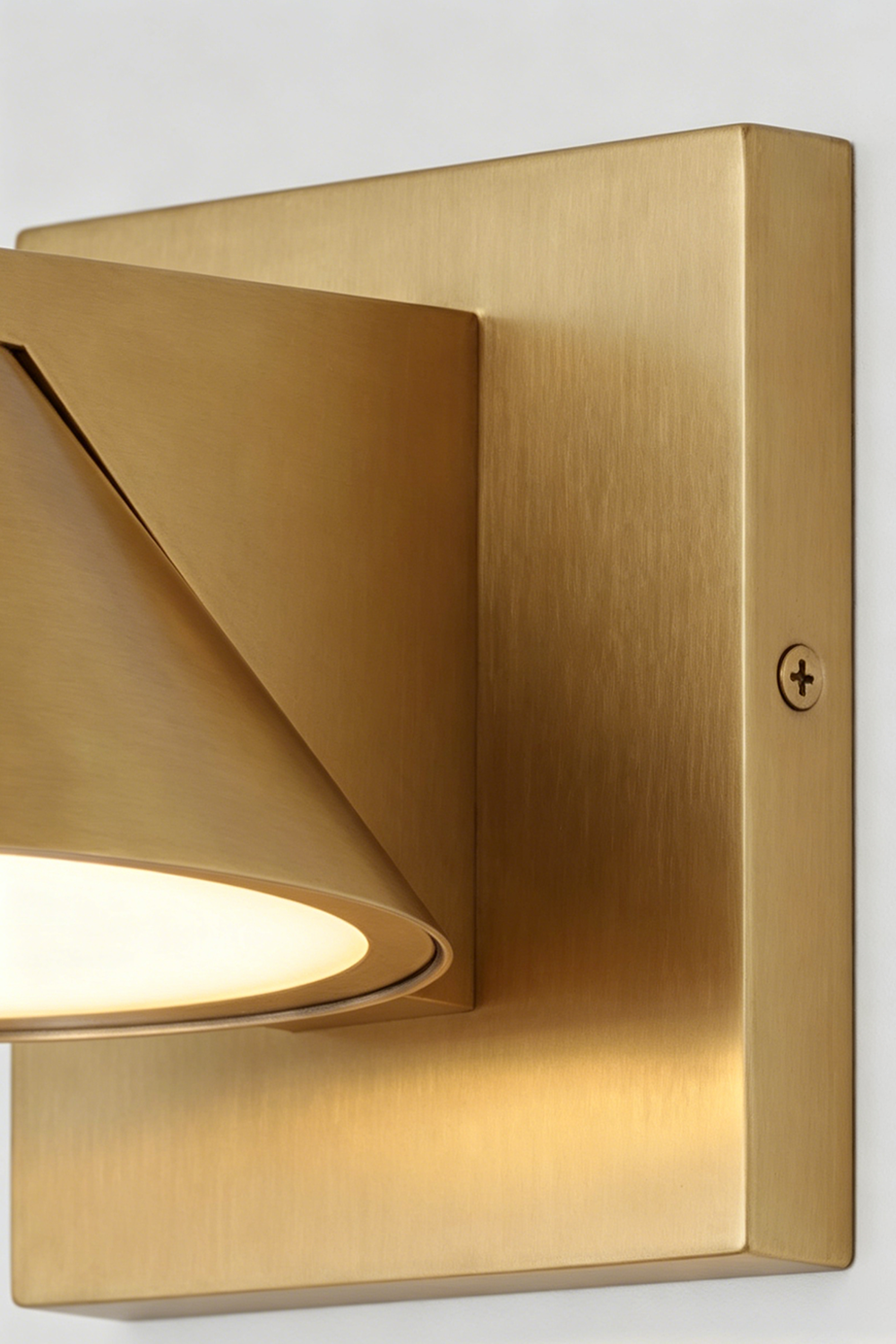 Kaelen Brass Cone Wall Sconce | Backplate Detail | Close-up architectural view focusing on the sleek brushed gold brass finish of the square mounting base plate and cone arm | Detail shot | Samu Lamp