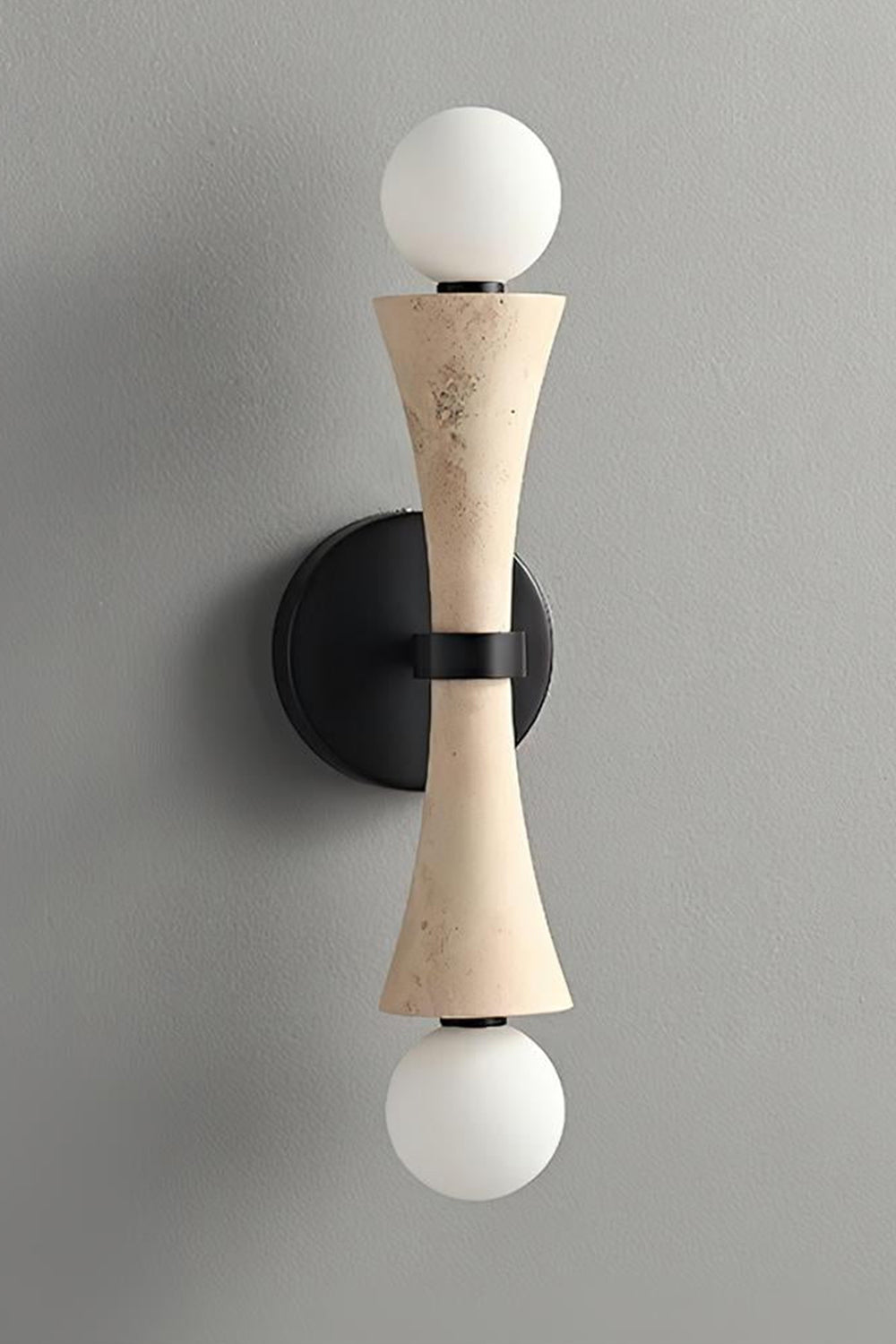 Katia Travertine Hourglass Wall Lamp | Travertine, Metal | Studio variant product view featuring the classic natural beige travertine stone hourglass body paired with black hardware | Samu Lamp
