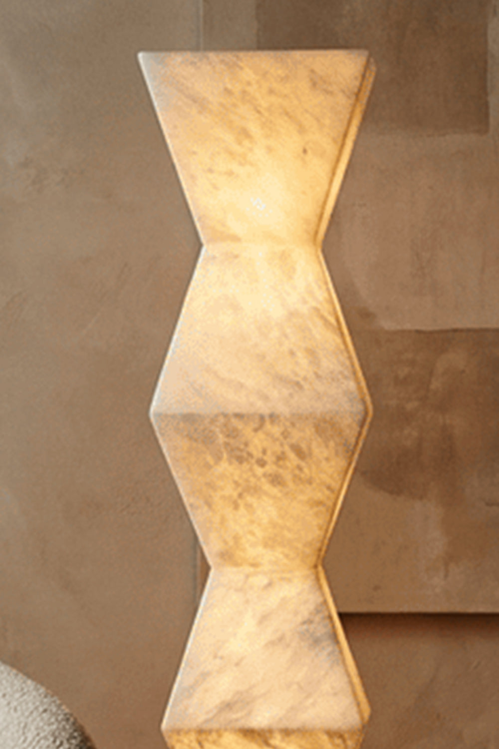 Kellan Geometric Alabaster Floor Lamp | Alabaster, Metal | Close-up focus on the stacked faceted geometric hourglass shapes of the lit translucent alabaster column showing unique veining | Detail shot | Samu Lamp