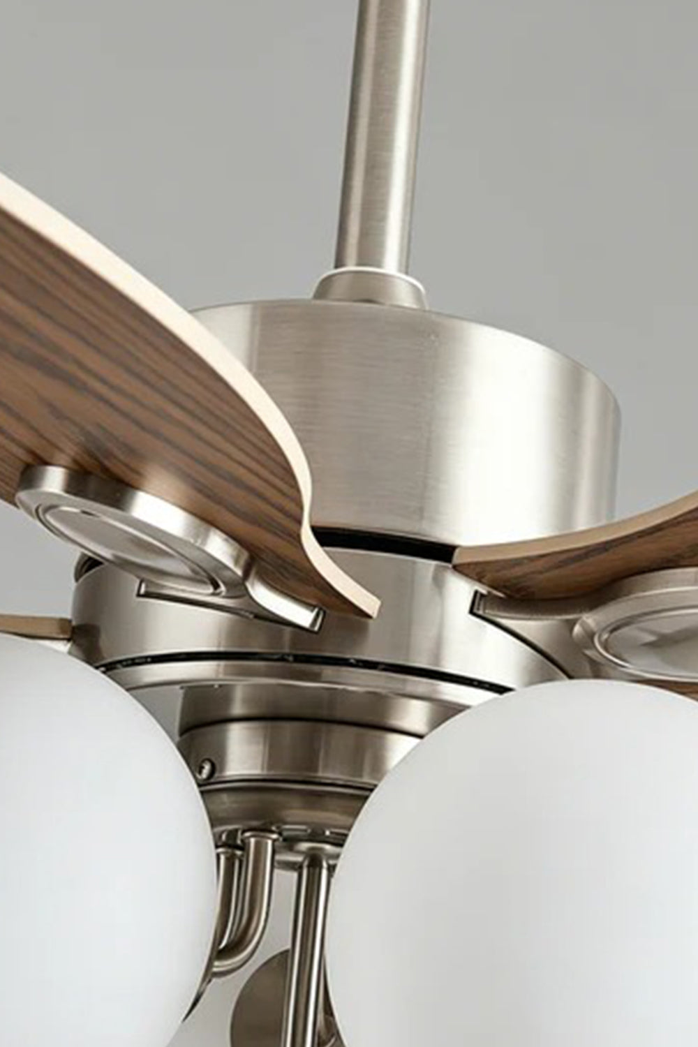 Keller Wooden Ceiling Fan Light | Wood, Glass, Metal | Detailed close-up shot focusing on the premium brushed silver metallic motor housing, dark wood blade connections, and white glass globes | Detail shot | Samu Lamp