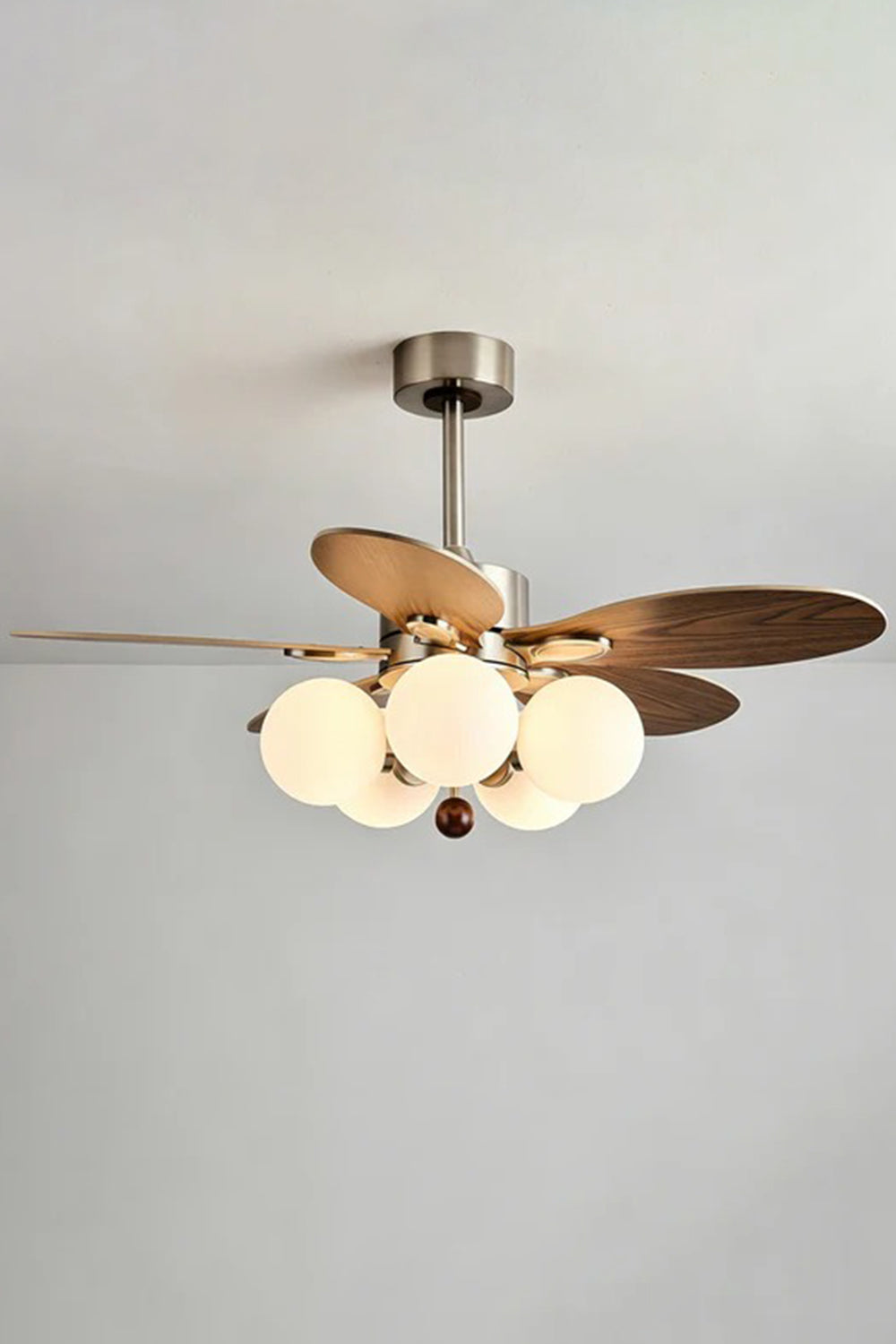 Keller Wooden Ceiling Fan Light | Wood, Glass, Metal | Studio front view of the fully illuminated wooden ceiling fan fixture hanging against a plain off-white background wall | Samu Lamp
