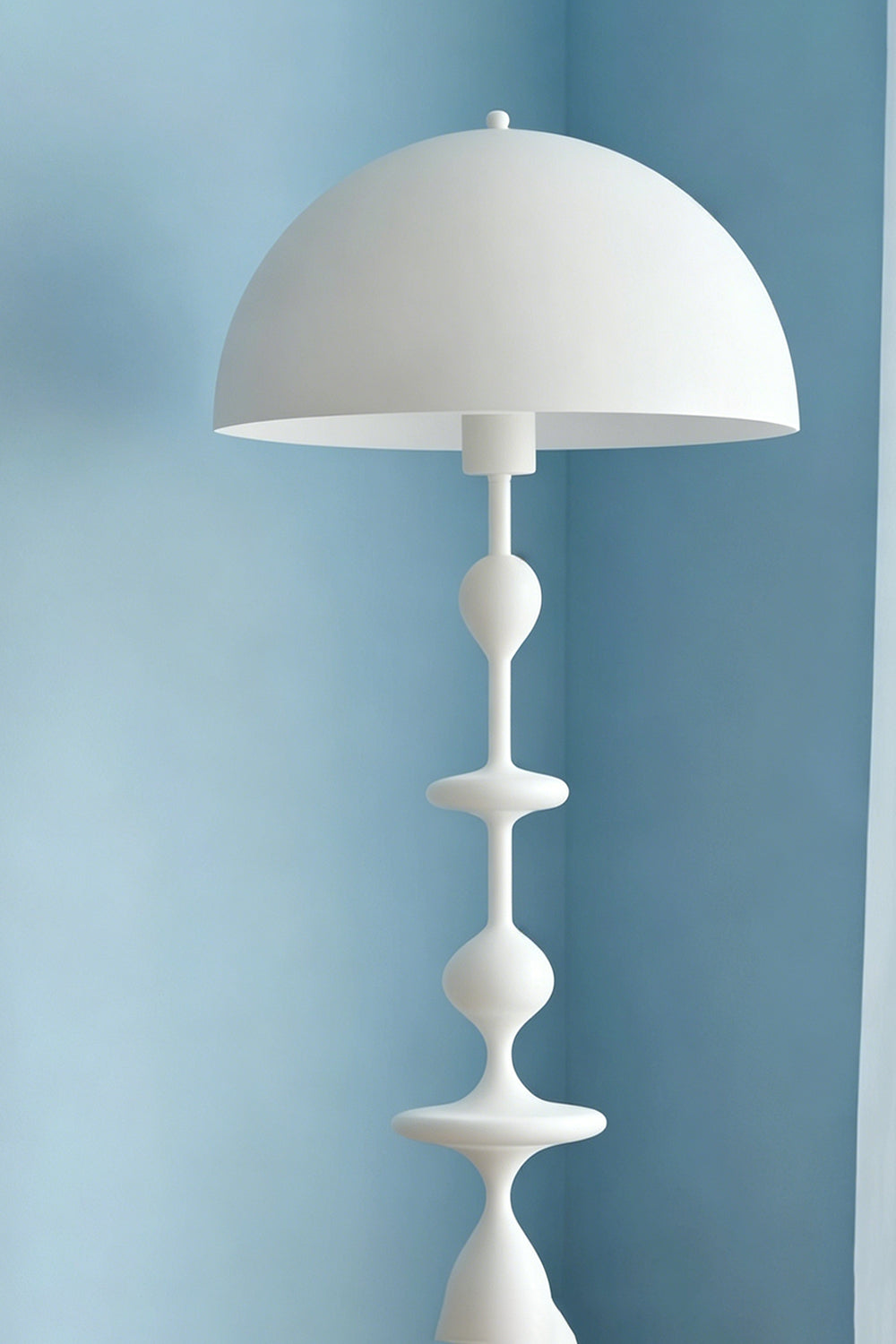 Kira Beaded Mushroom Floor Lamp | Metal, Glossy Finish | Close-up shot of the white mushroom dome shade and top beaded accents contrasted against a soft blue wall | Samu Lamp