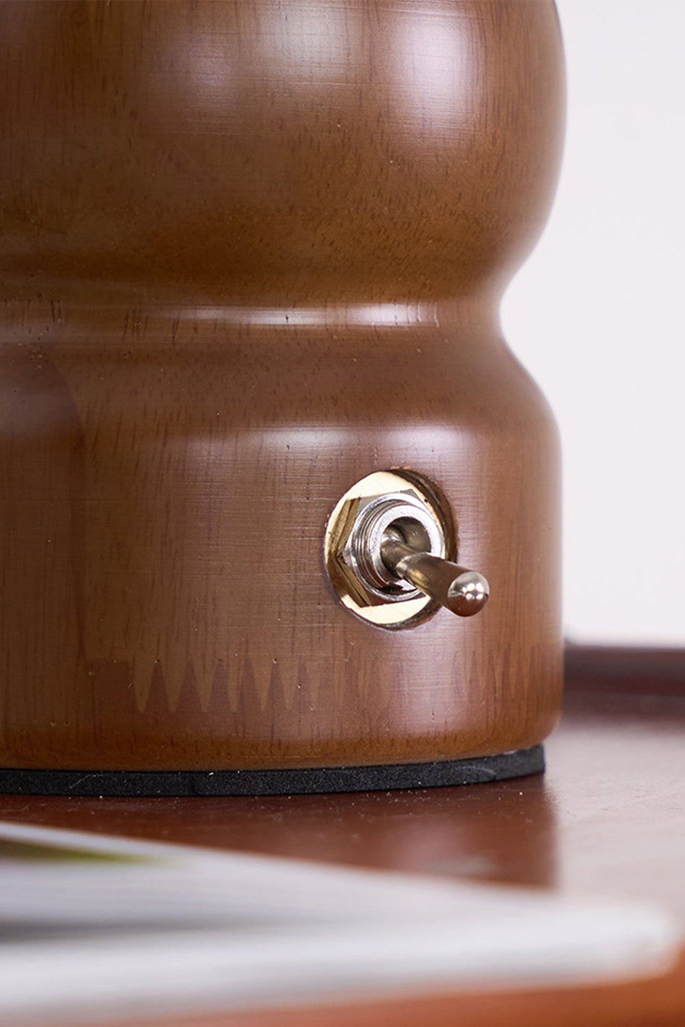 Kira Sculpted Mushroom Table Lamp | Wood, Glass | Detailed close-up showing the sleek metallic toggle switch embedded in the rich dark walnut wood base | Detail shot | Samu Lamp