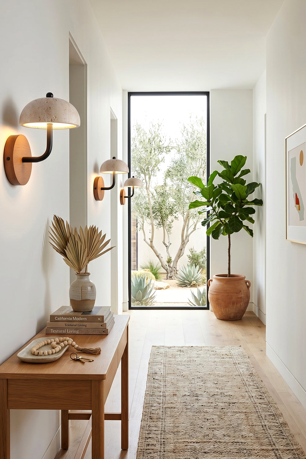 Koba Travertine Mushroom Wall Lamp | Travertine, Wood, Metal | Mounted along a bright modern hallway above a wooden console table with earthy decorative pieces | Samu Lamp