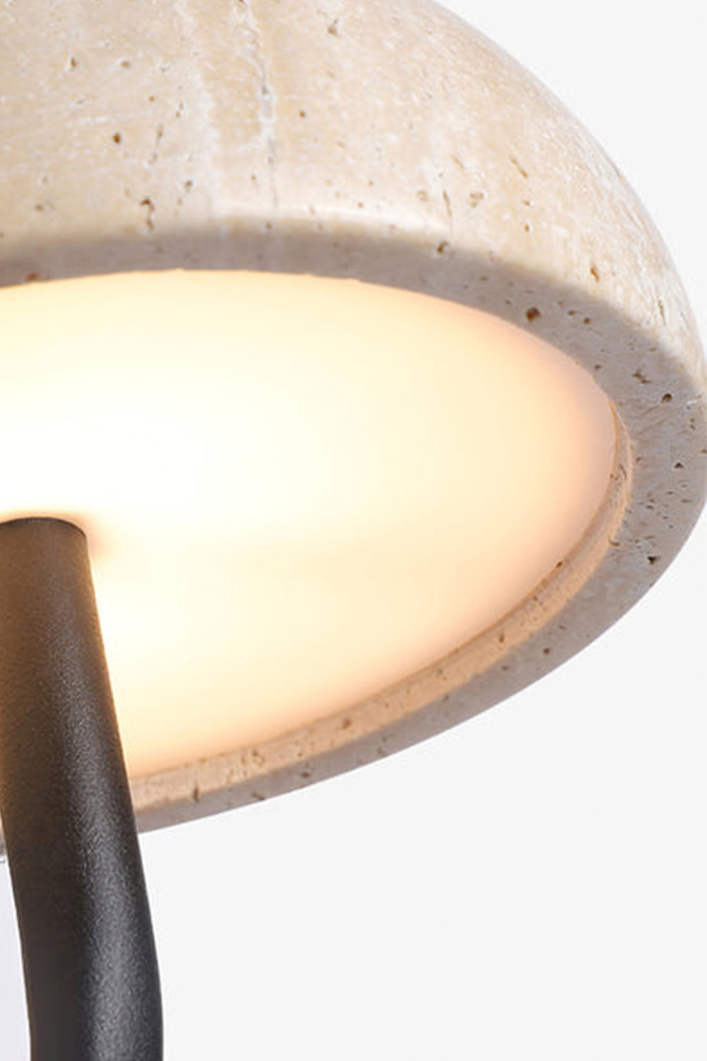Koba Travertine Mushroom Wall Lamp | Travertine, Wood, Metal | Detailed close-up showing the warm diffused downlight glowing underneath the porous travertine mushroom shade | Detail shot | Samu Lamp