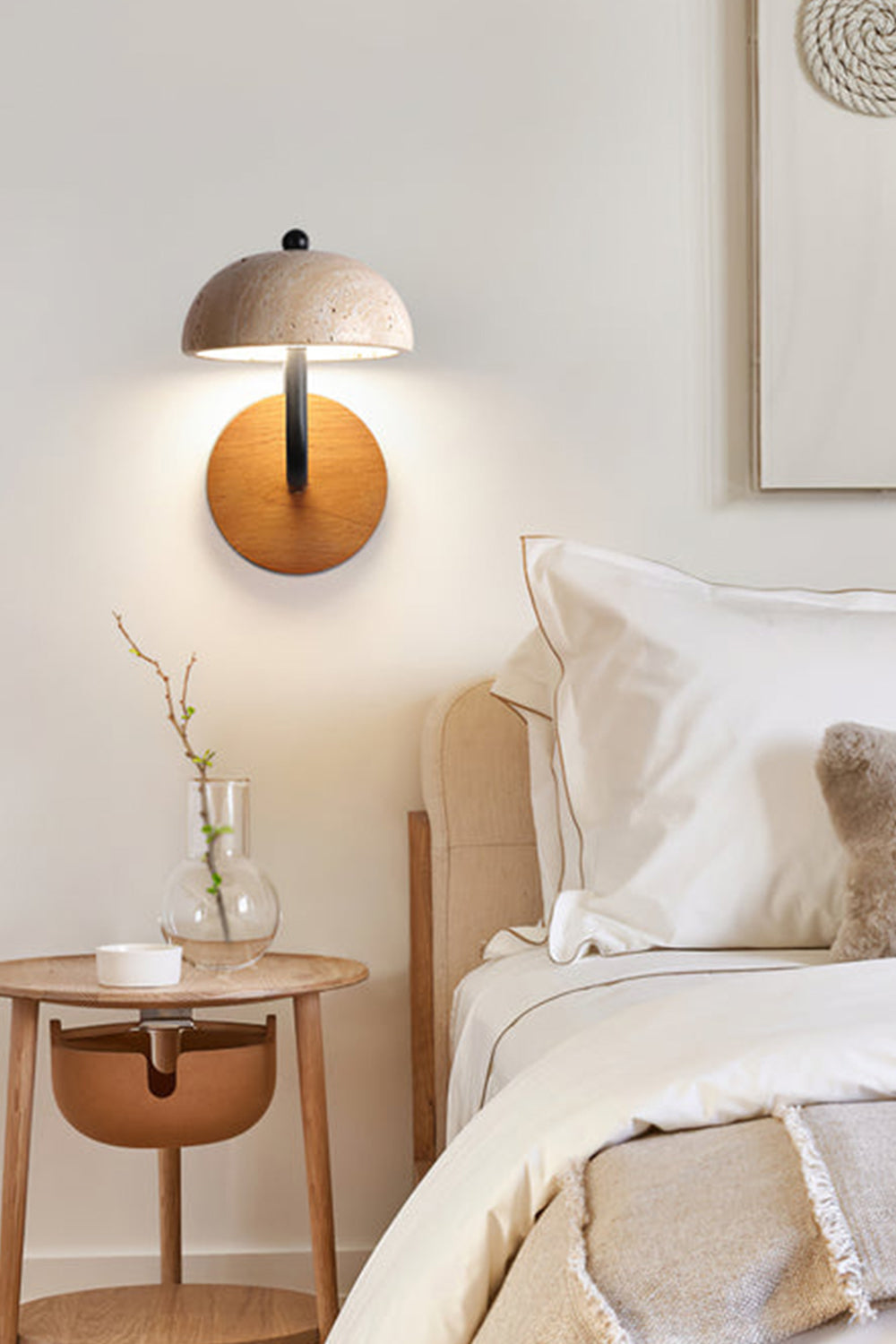 Koba Travertine Mushroom Wall Lamp | Travertine, Wood, Metal | Mounted as a cozy bedside reading light above a wooden nightstand in a soft cream-toned bedroom | Samu Lamp