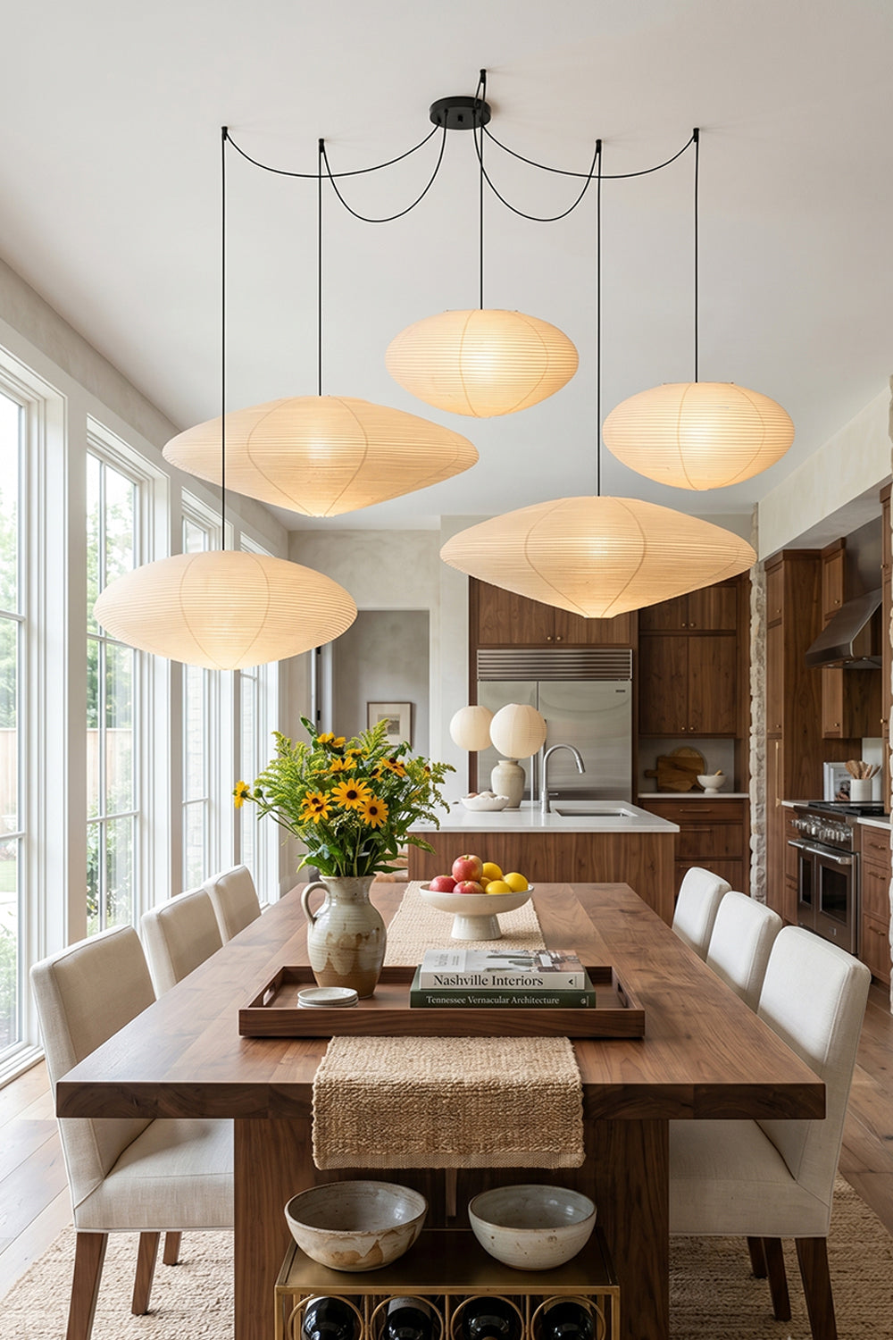 Komorebi Mulberry Paper Pendant Light | Paper, Bamboo | Four multi-shaped mulberry paper lanterns hanging elegantly as a clustered centerpiece over a long oak dining table | Samu Lamp