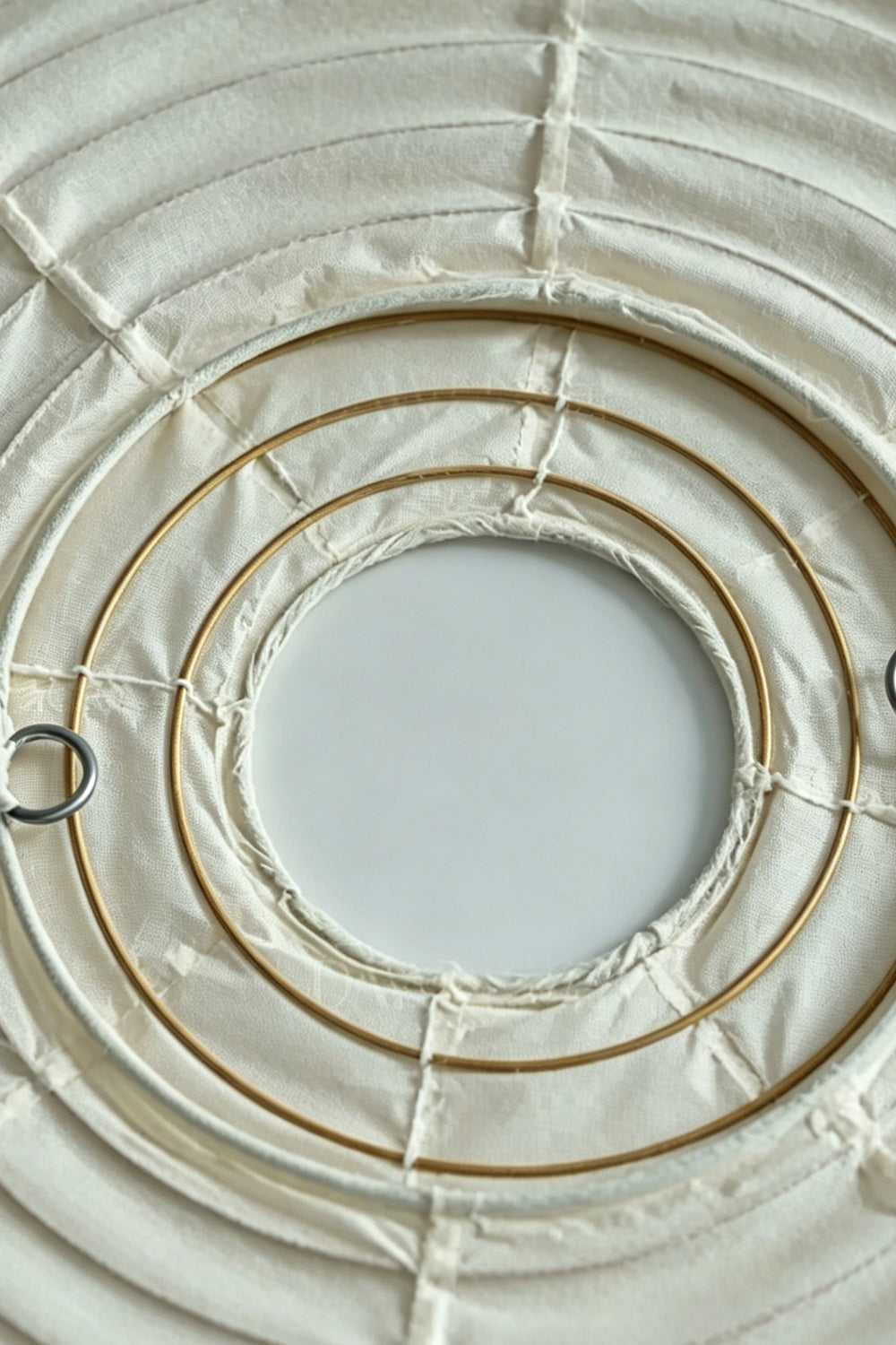 Komorebi Mulberry Paper Pendant Light | Paper, Bamboo | Detail shot of collapsed or flat-packed circular bamboo rib rings of the mulberry paper lampshade structure | Detail shot | Samu Lamp