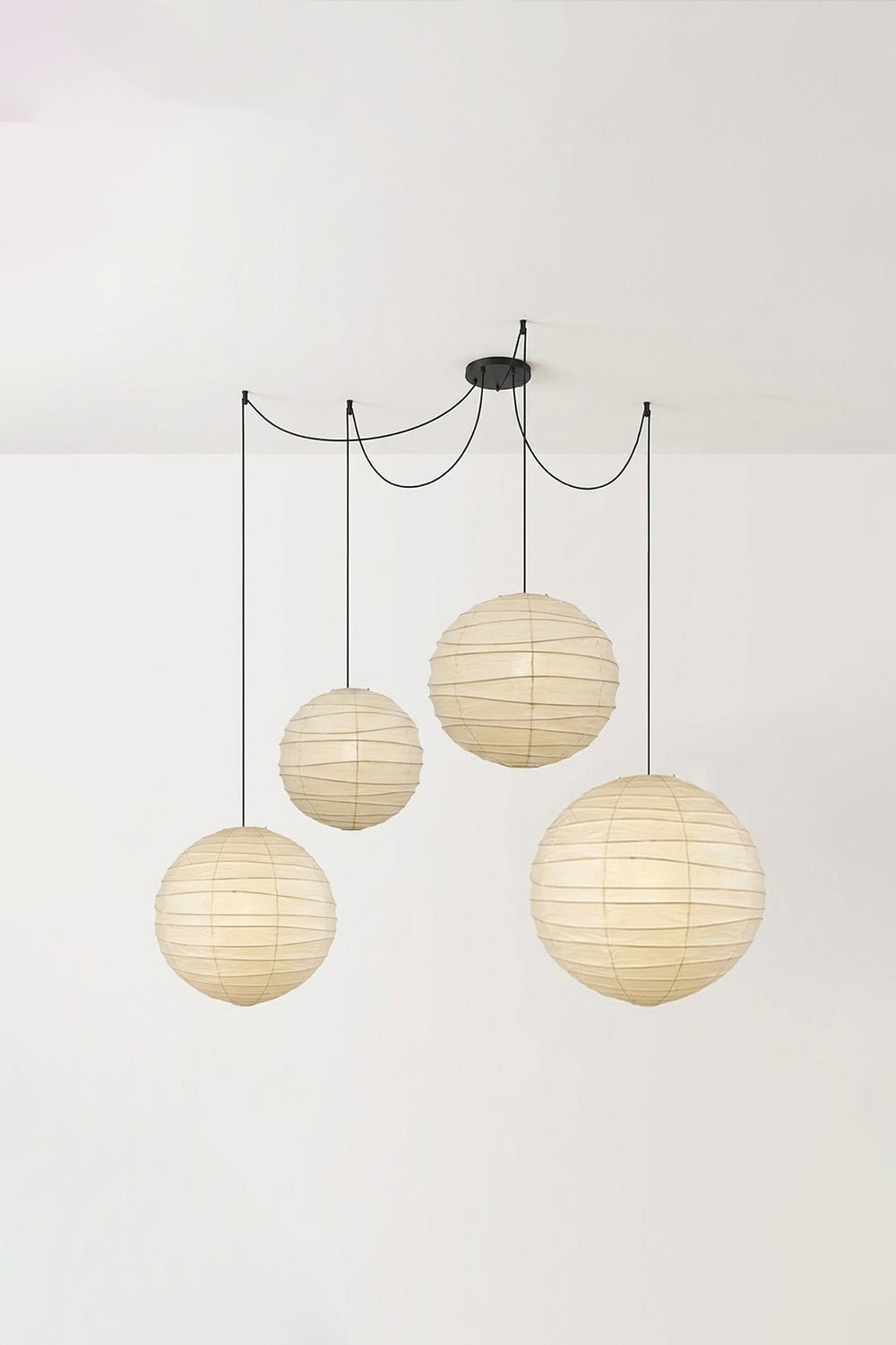 Komorebi Mulberry Paper Pendant Light | Paper, Bamboo | Studio view of a fully lit 4-light cluster combination radiating a cozy golden ambient light against a white wall | Samu Lamp