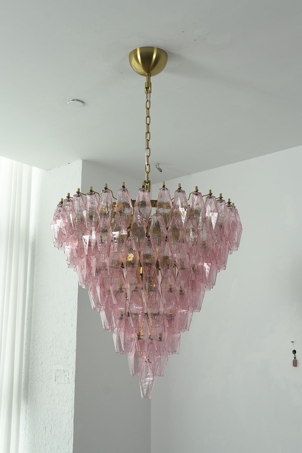 Lauragne Pink Faceted Glass Cascade Chandelier | Pink Faceted Glass and Brass | Full vertical view of the glowing pink glass chandelier on white background | Samu Lamp