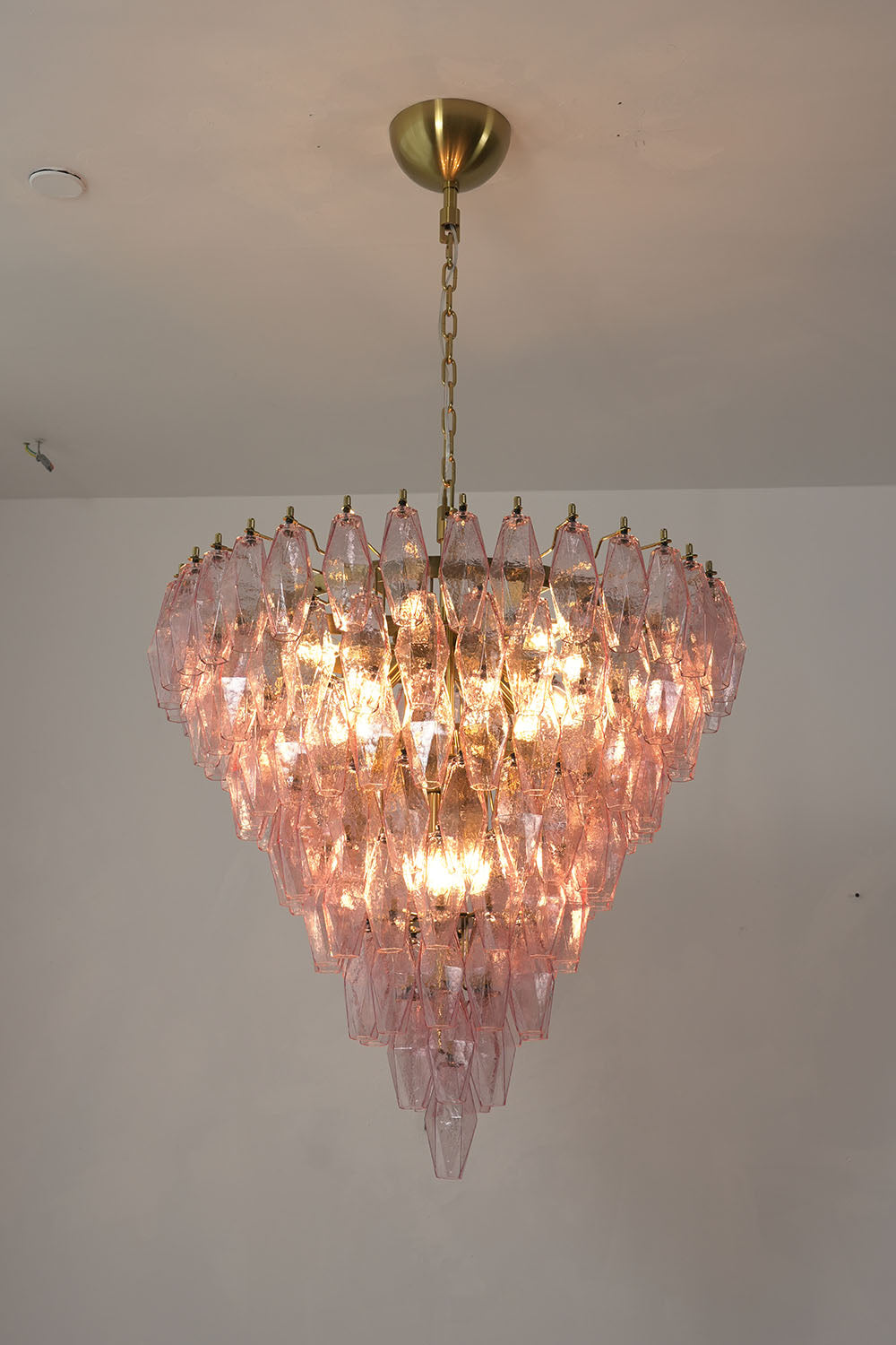 Lauragne Pink Faceted Glass Cascade Chandelier | Pink Faceted Glass and Brass | Full product view glowing brightly against a plain backdrop | Samu Lamp