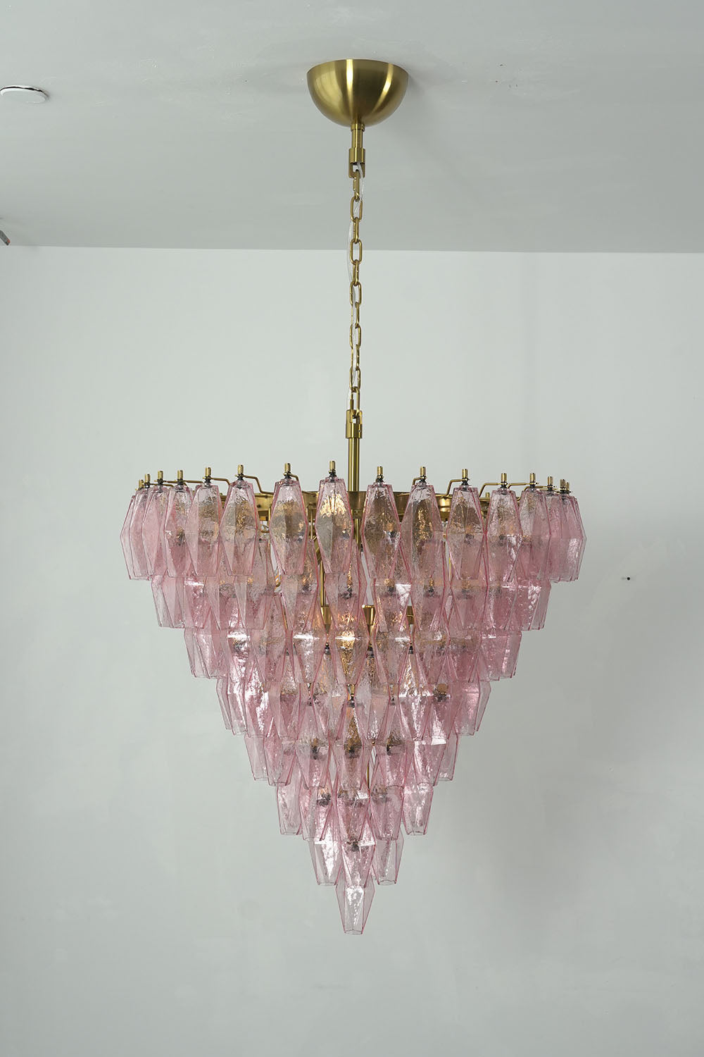 Lauragne Pink Faceted Glass Cascade Chandelier | Pink Faceted Glass and Brass | Studio product view illuminated gracefully on a neutral wall | Samu Lamp