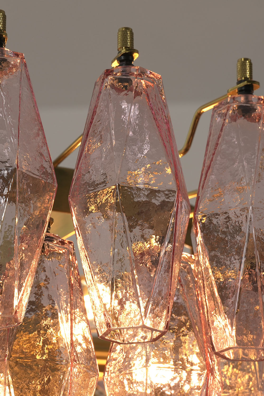 Lauragne Pink Faceted Glass Cascade Chandelier | Pink Faceted Glass and Brass | Close-up view of glowing pink faceted glass prisms and brass hooks | Samu Lamp