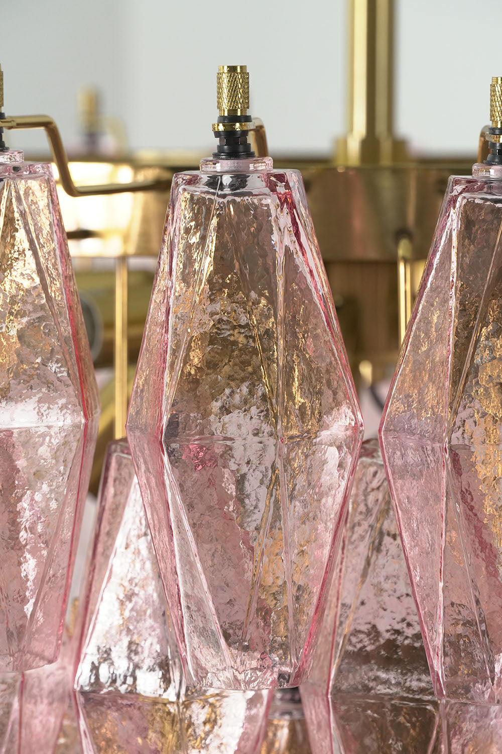 Lauragne Pink Faceted Glass Cascade Chandelier | Pink Faceted Glass and Brass | Close-up view of an illuminated clear pink faceted glass prism | Samu Lamp