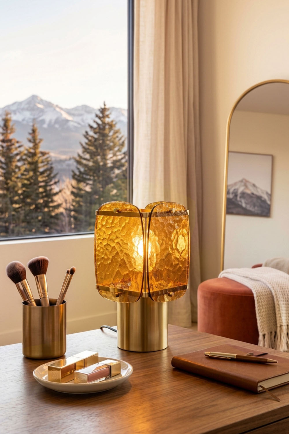 Lesquin Hammered Amber Glass Table Lamp | Hammered Amber Glass and Brass | Positioned on a wooden desk near a tall window with scenic snowy mountain views | Samu Lamp