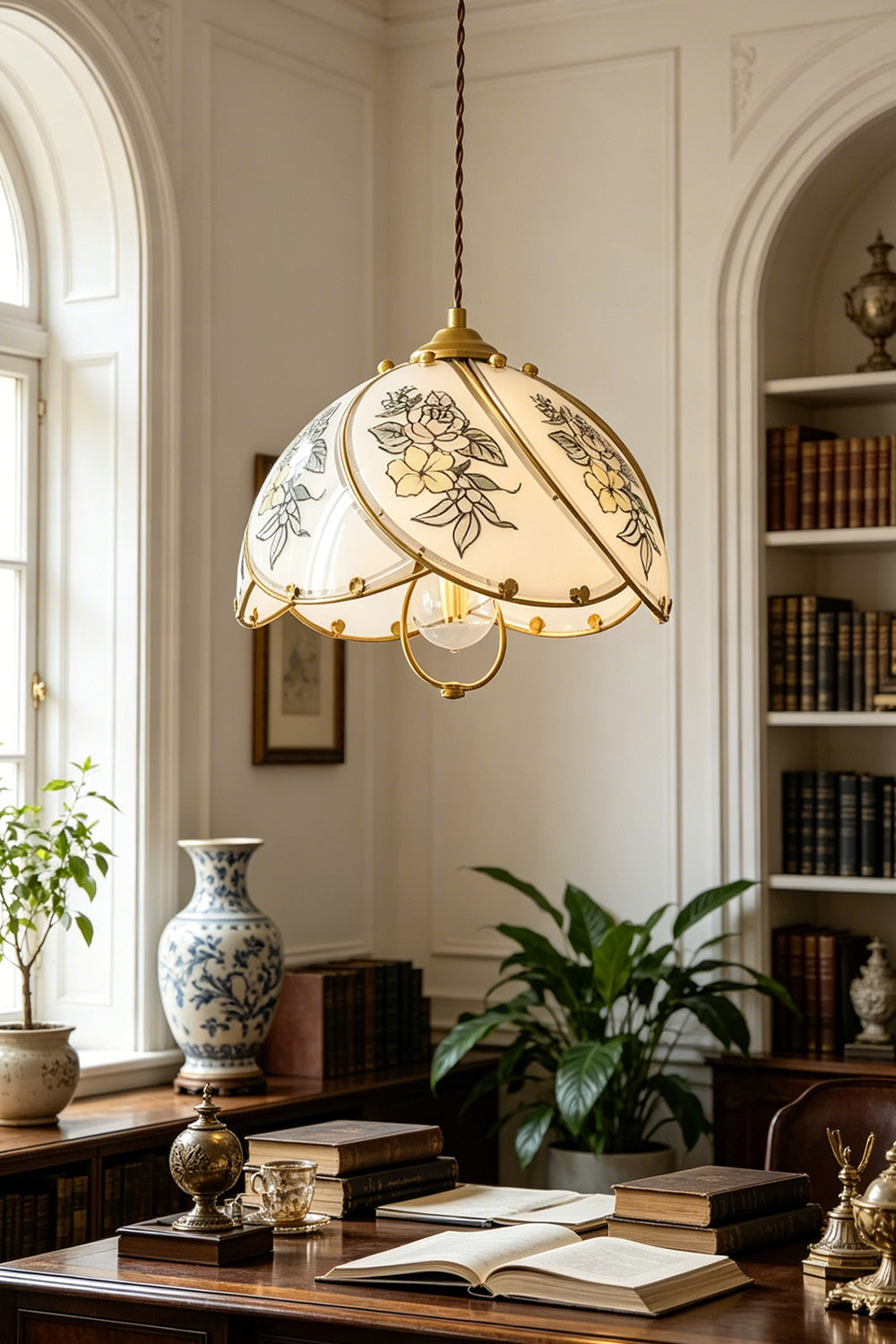 Lillian Retro Floral Pendant Lamp | Glass, Metal | Suspended over a traditional dark wood executive writing desk filled with books and plants in a bright library room | Samu Lamp