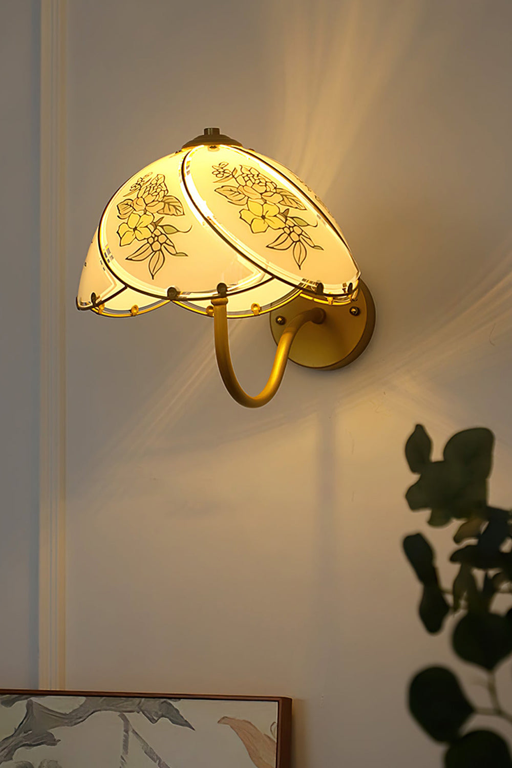 Lillian Retro Floral Wall Lamp | Glass, Metal | Close-up side profile view of the lit lamp radiating a warm golden glow on a wall in low light | Samu Lamp