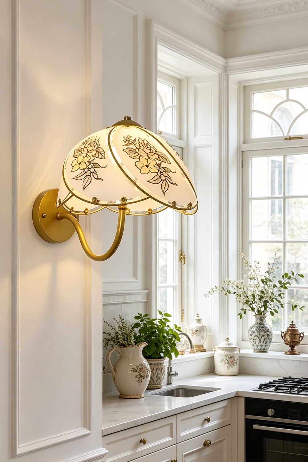 Lillian Retro Floral Wall Lamp | Glass, Metal | Mounted above a clean white kitchen countertop next to a window with potted plants | Samu Lamp