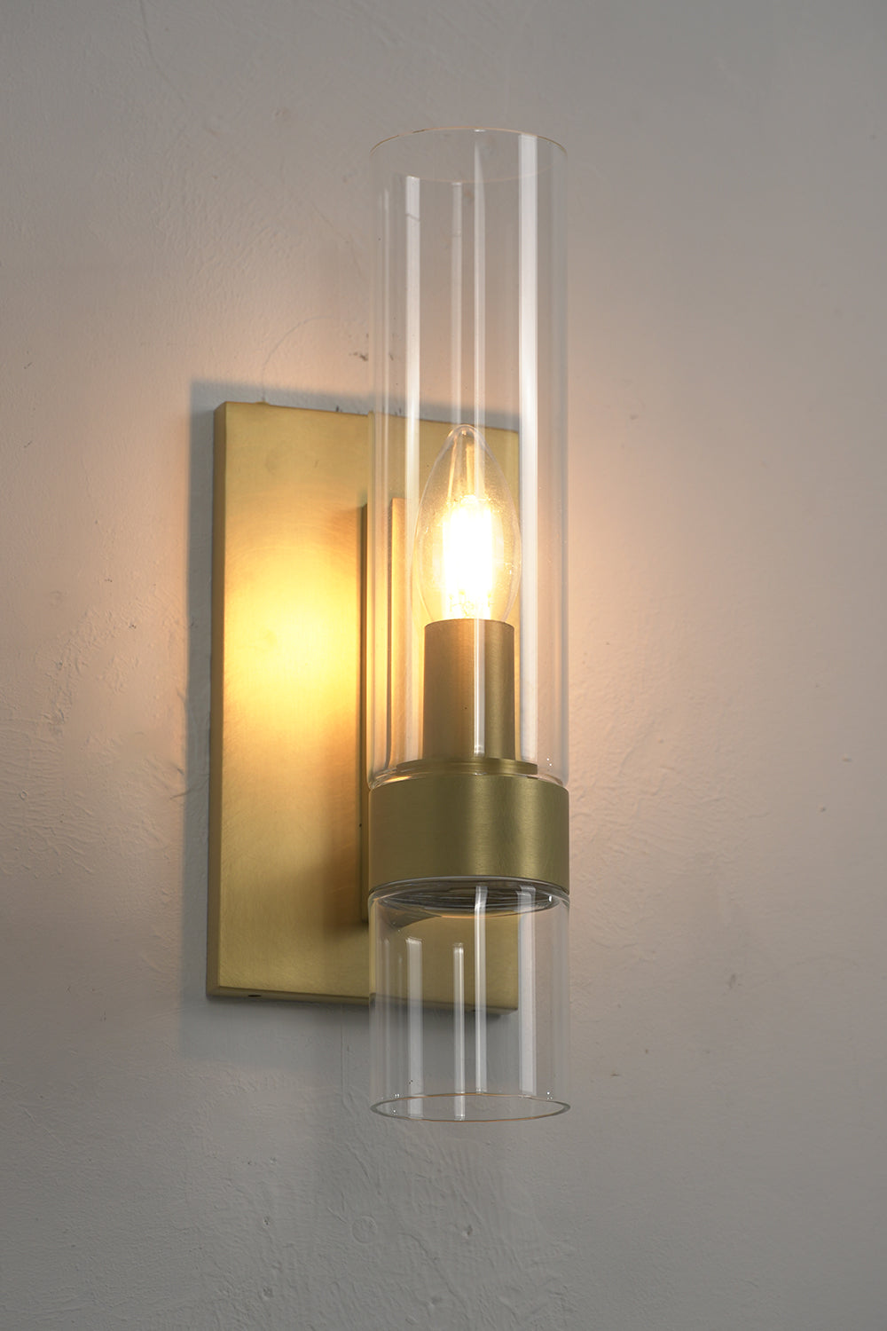 Lit brass linear wall lamp | Brass, Glass | Side perspective showing warm glow and glass texture | Samu Lamp