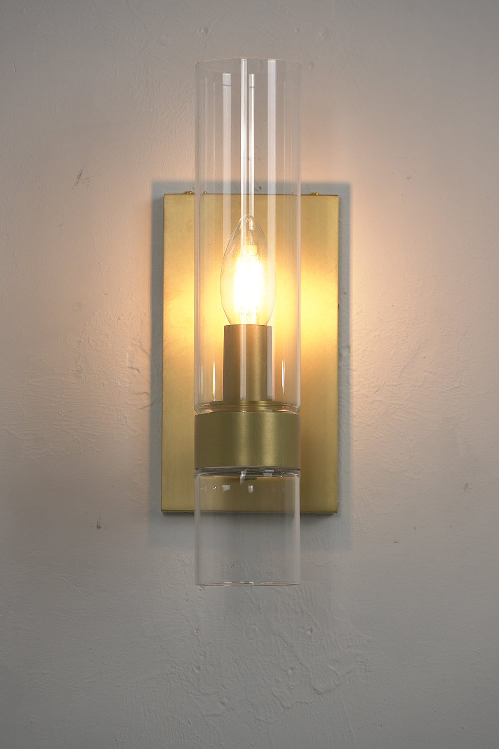 Front view of lit linear brass sconce | Brass, Glass | Close-up showing the candle bulb glow | Samu Lamp