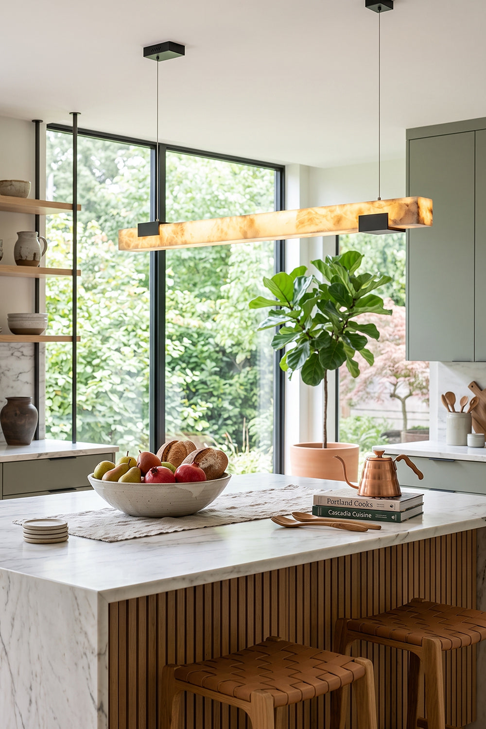 Liora Linear Alabaster Pendant Light | Natural Alabaster and Black Metal | Suspended over a kitchen island featuring a bowl of fresh fruits next to a bright window | Samu Lamp