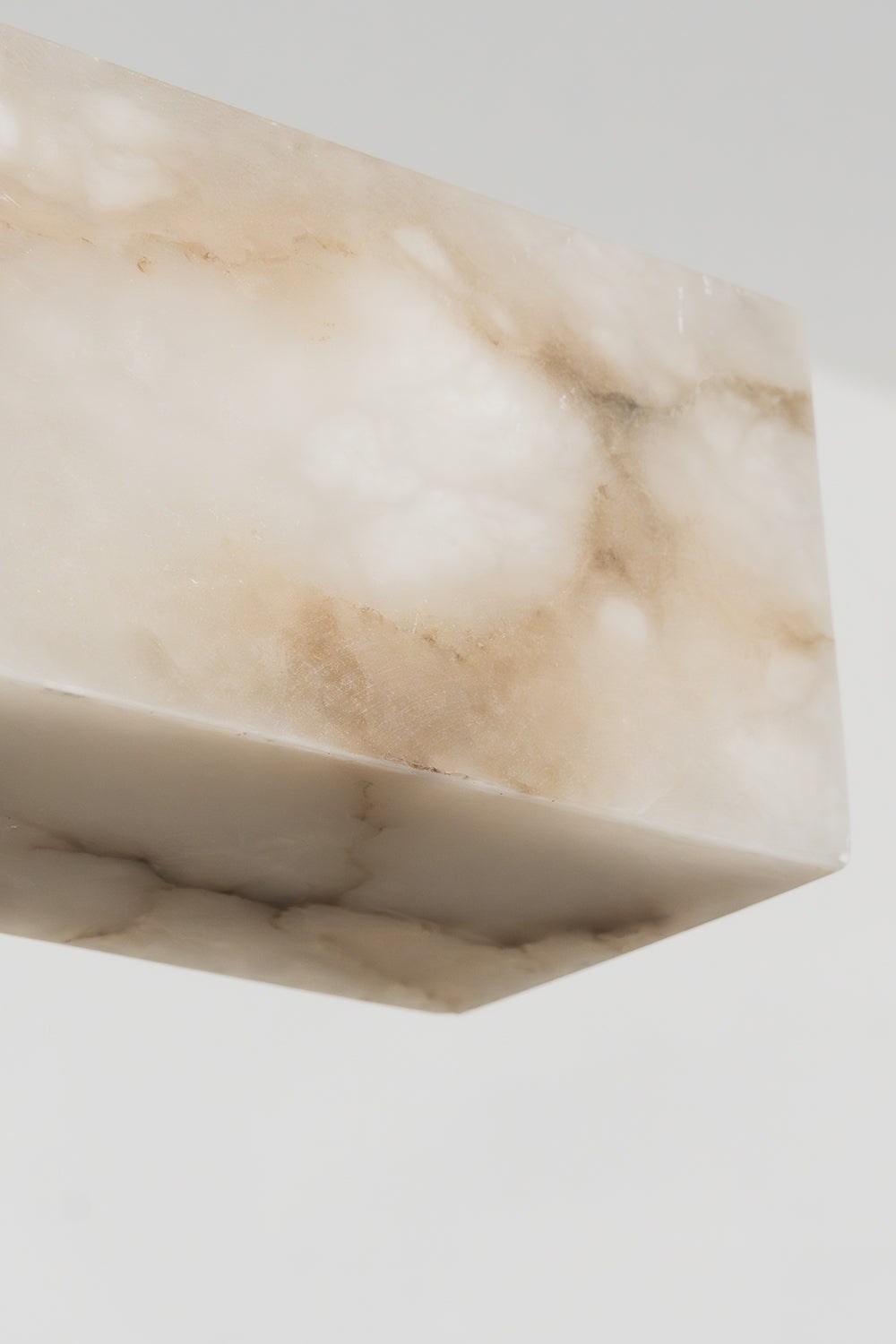 Liora Linear Alabaster Pendant Light | Natural Alabaster and Black Metal | Close-up view of the unlit white stone end profile showcasing its natural organic texture | Samu Lamp