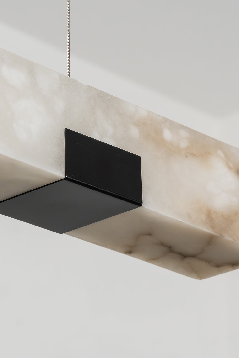 Liora Linear Alabaster Pendant Light | Natural Alabaster and Black Metal | Close-up view of the unlit linear block featuring the matte black metal support plate underneath | Samu Lamp