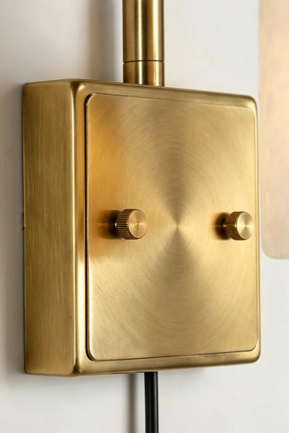 Liora Scalloped Alabaster Wall Sconce | Natural Alabaster and Brushed Brass | Detailed close-up view highlighting the smooth texture and screws of the rectangular brass mounting plate | Samu Lamp