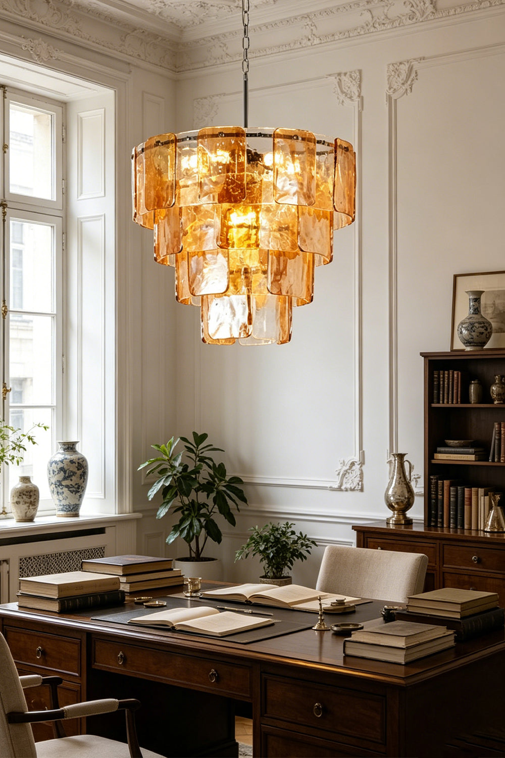 Lucia Tiered Amber Glass Chandelier | Glass, Metal | Illuminating a traditional study room or dining space, casting a rich golden glow over a dark wood table with ornate wall decor | Samu Lamp