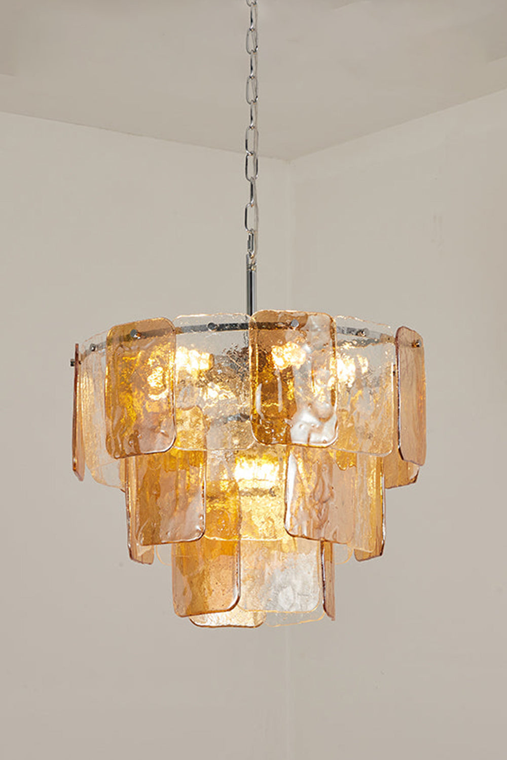 Lucia Tiered Amber Glass Chandelier | Glass, Metal | Studio view of a smaller three-tier variant fully lit against a plain off-white background | Samu Lamp