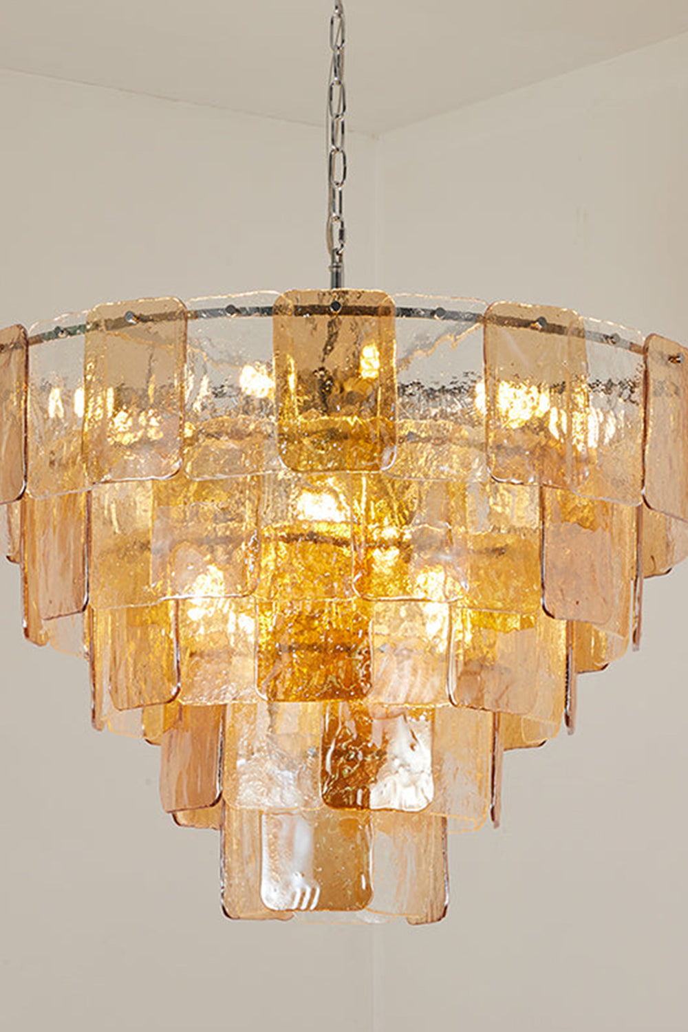Lucia Tiered Amber Glass Chandelier | Glass, Metal | Detailed studio shot highlighting the overlapping concentric layers of glowing amber glass tiles and chrome hanging chain | Detail shot | Samu Lamp