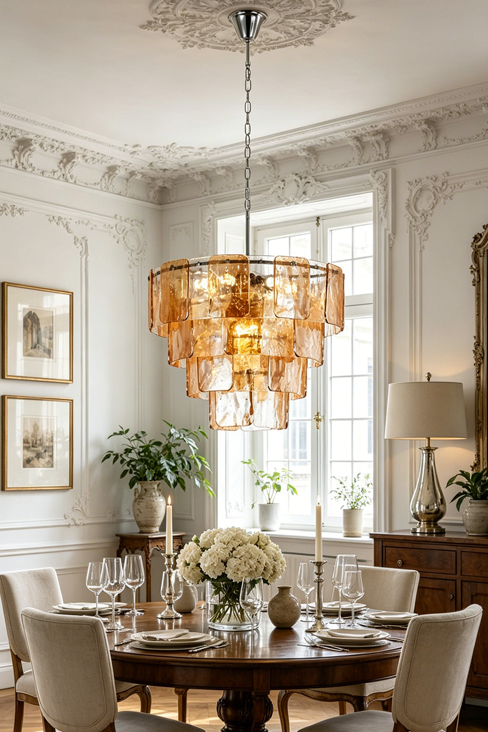 Lucia Tiered Amber Glass Chandelier | Glass, Metal | Suspended as an elegant statement centerpiece above a round dark wood dining table in a classical room with ornate wall moldings | Samu Lamp
