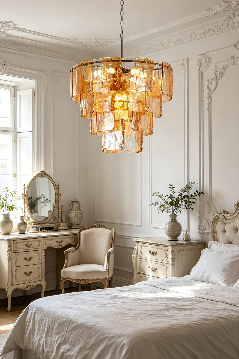 Lucia Tiered Amber Glass Chandelier | Glass, Metal | Providing a warm amber glow in a refined classical bedroom suite next to a vintage vanity table and white bedding | Samu Lamp