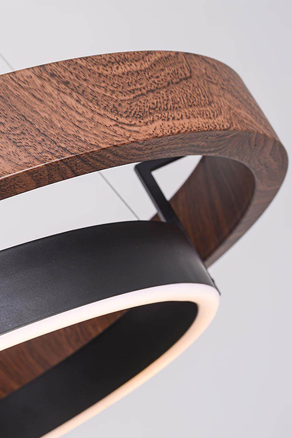 Close-up of the warm walnut-grain finish and matte black metal of the Lysander Dual-Ring LED Chandelier.