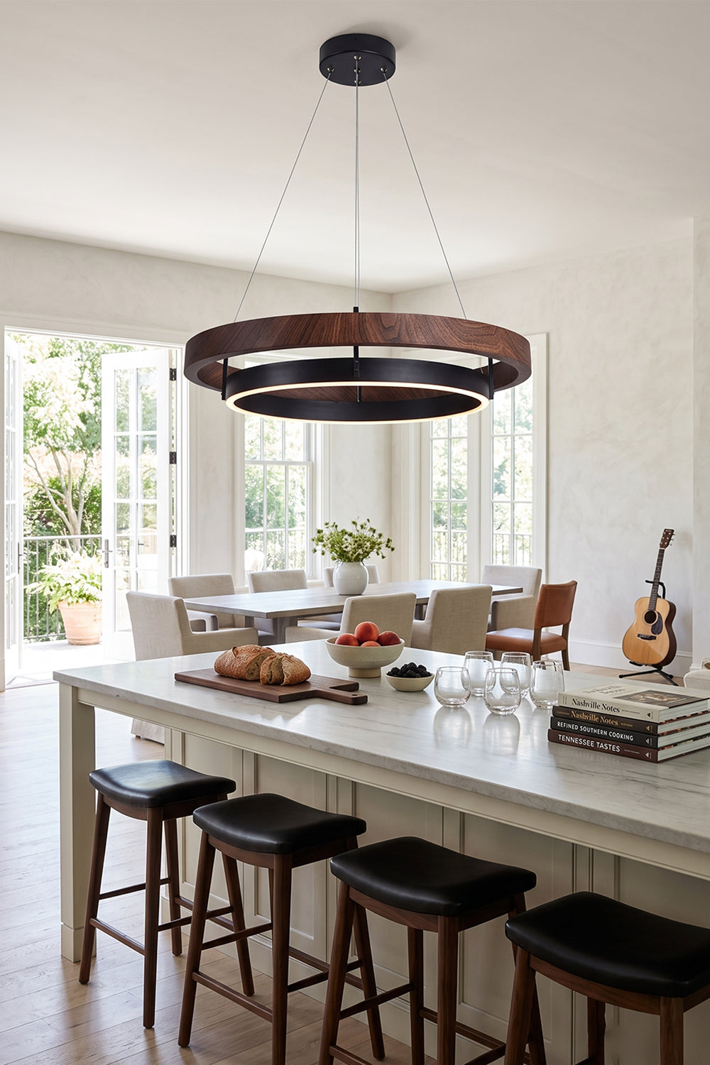 Lysander Dual-Ring LED Chandelier hanging above a kitchen island with a modern decor, showcasing its warm walnut-grain finish.