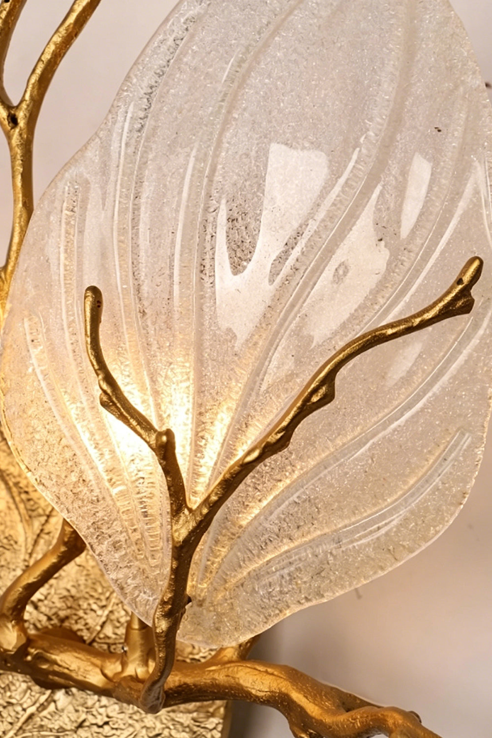Magnolia Arbor Brass Wall Lamp | Brass, Glass | Extreme close-up of the textured clear glass shade, detailing the bubbles and icy texture under warm light | Detail shot | Samu Lamp